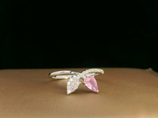 18K white gold bypass ring featuring 0.37ct pear pink sapphire and 0.15ct diamonds in a modern pear motif design.
