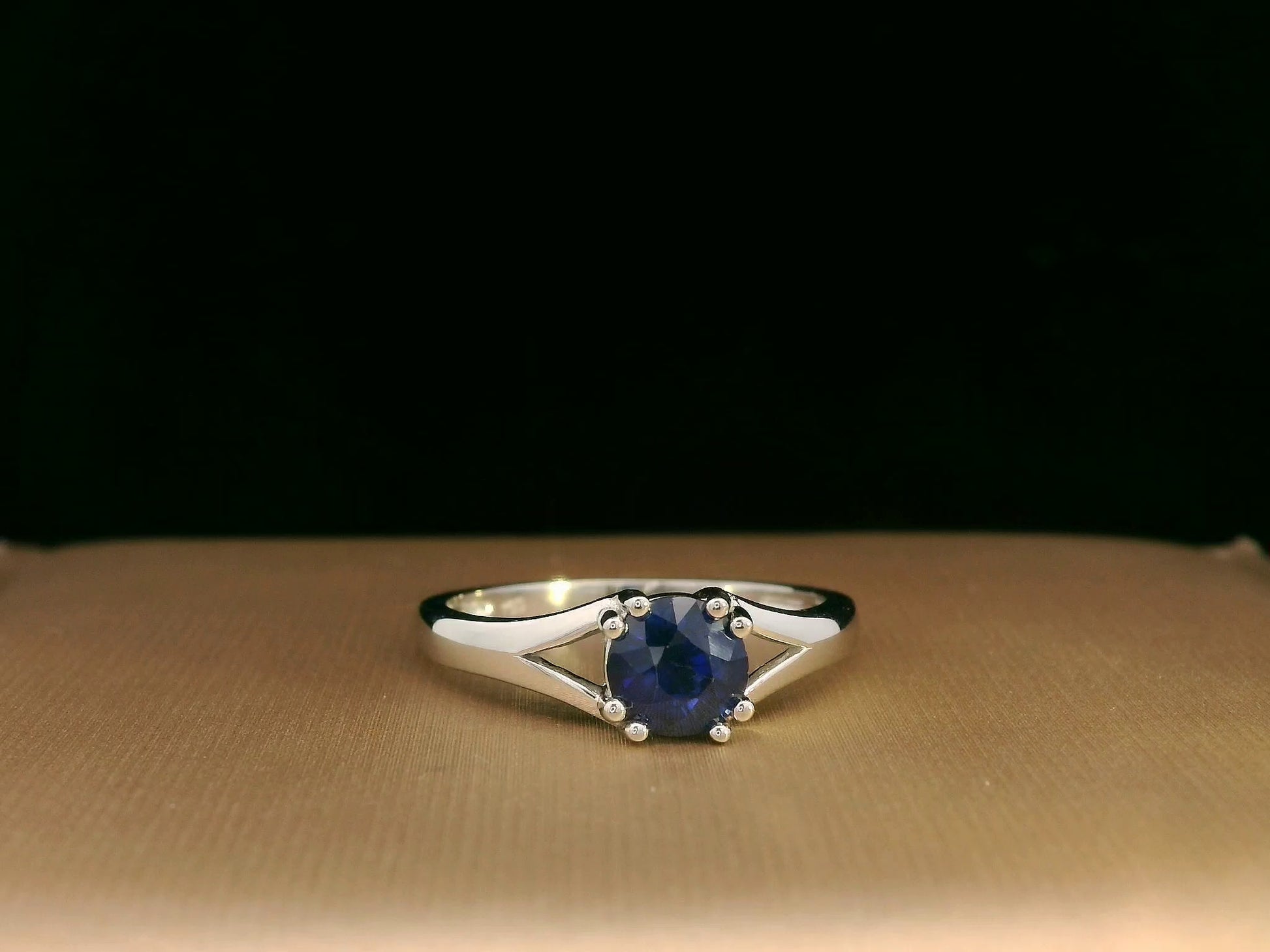 Round blue sapphire split-shank ring in 18K white gold