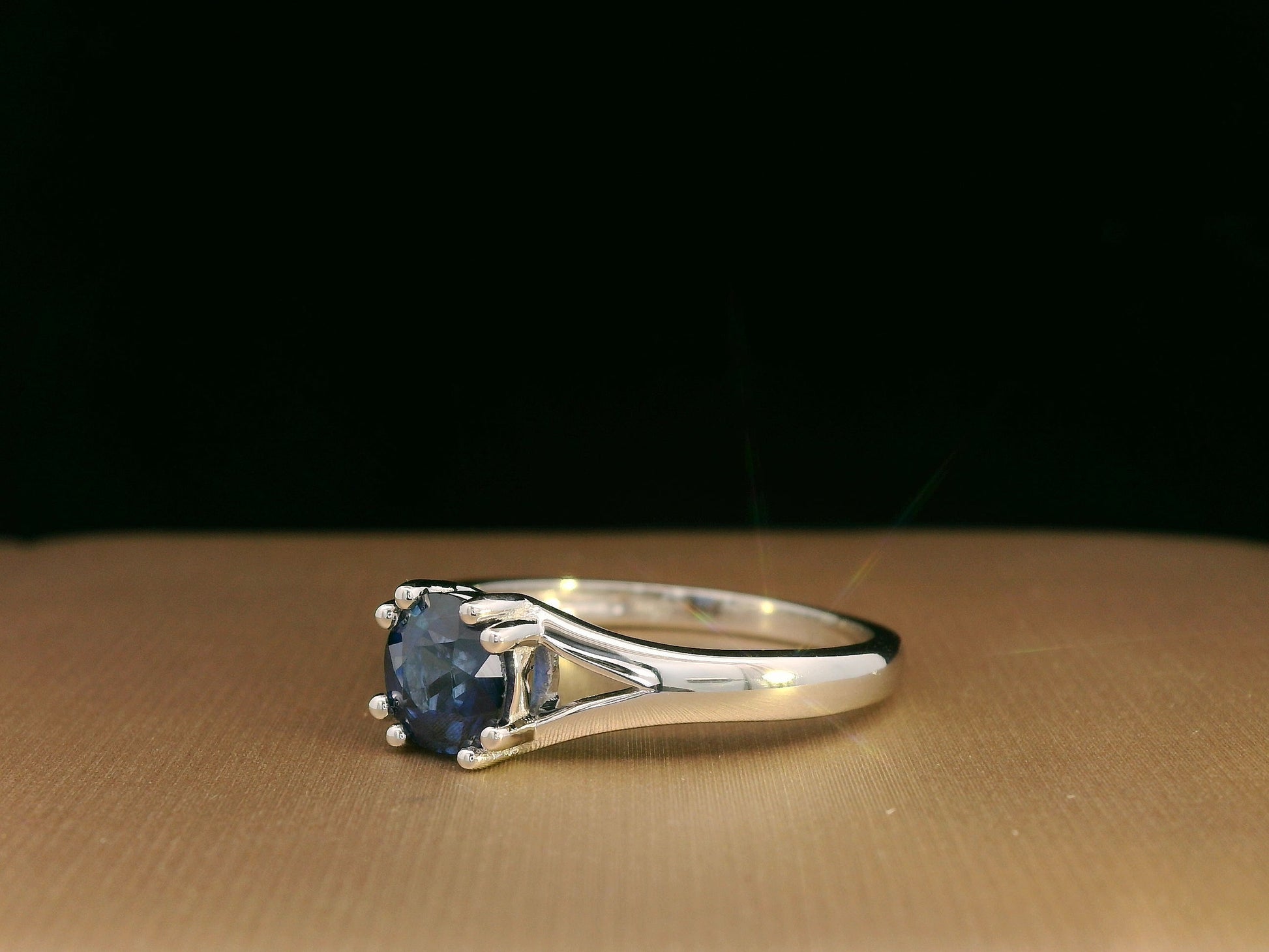Round blue sapphire split-shank ring in 18K white gold