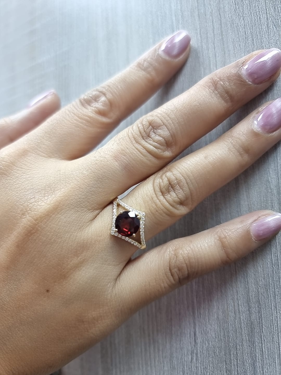 Round garnet split-shank ring with diamond accents in 18K yellow gold
