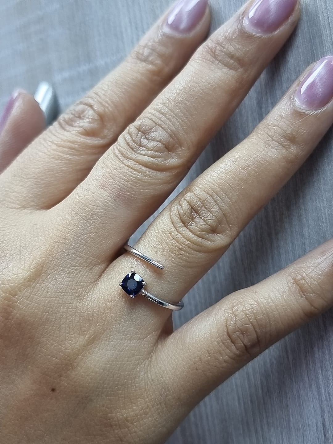 18K gold bypass ring with 0.49 carat cushion-cut blue sapphire, sleek modern design