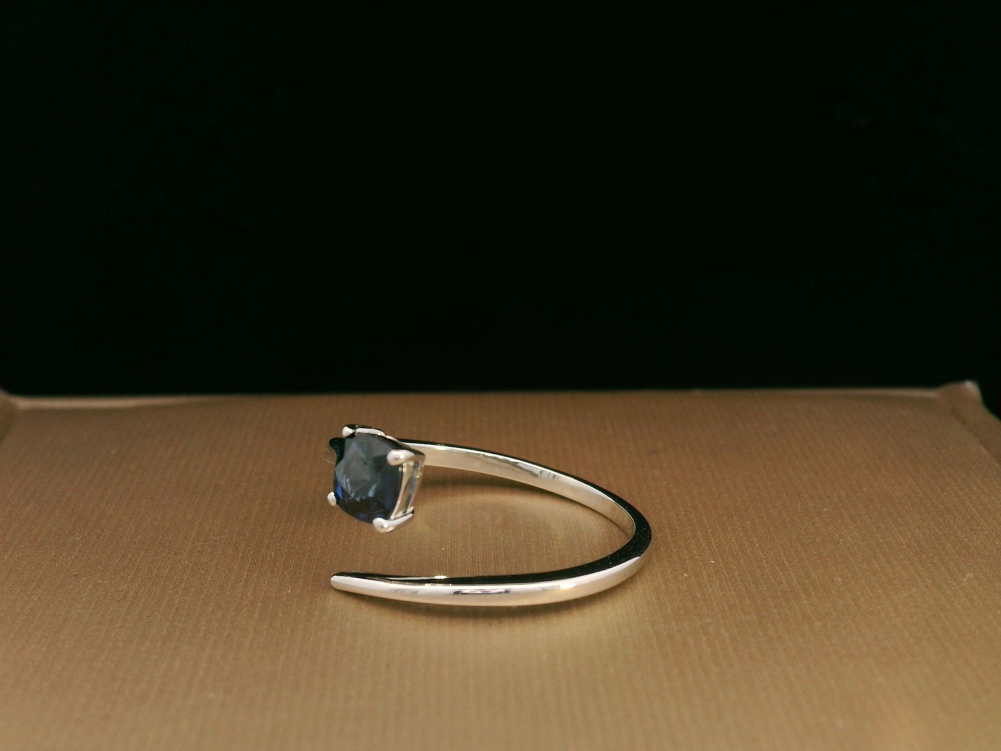 18K gold bypass ring with 0.49 carat cushion-cut blue sapphire, sleek modern design