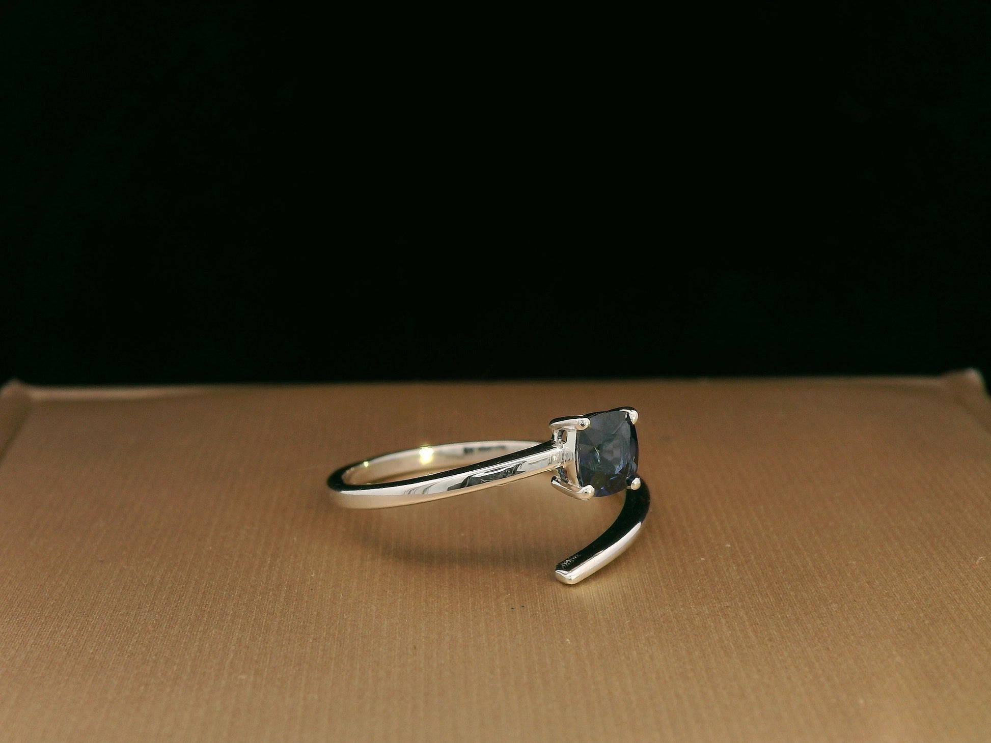 18K gold bypass ring with 0.49 carat cushion-cut blue sapphire, sleek modern design