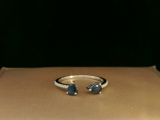 18K white gold open cuff ring with two teardrop-cut blue sapphires (0.70 carat) and 0.10 carat diamond pavé, modern minimalist design
