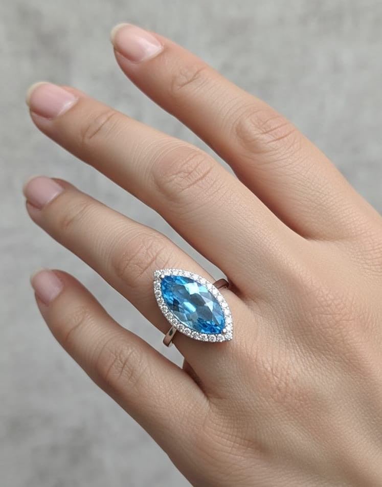 Marquise-cut blue topaz ring with diamond halo in 18K gold