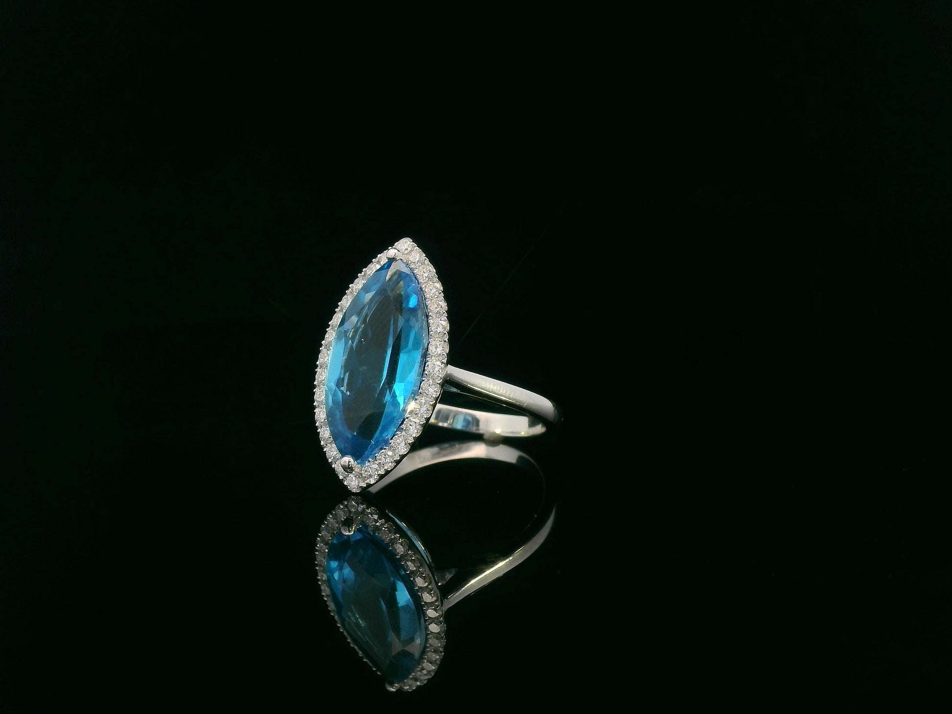 Marquise-cut blue topaz ring with diamond halo in 18K gold