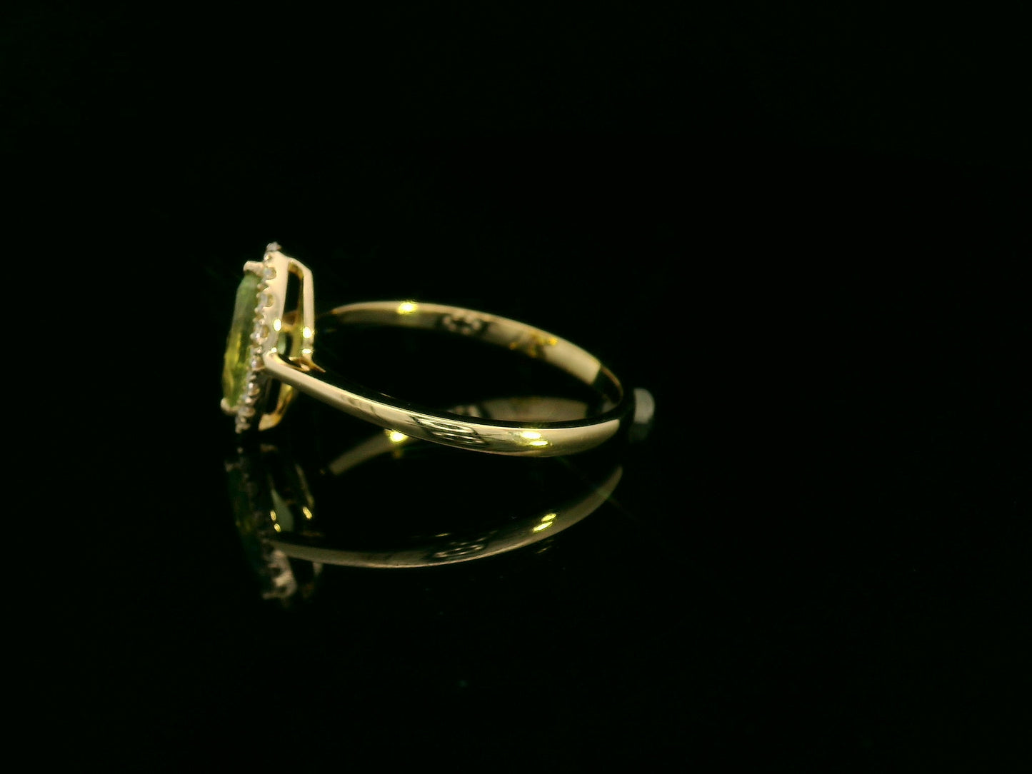 18k yellow gold ring featuring a 0.64ct marquise Peridot surrounded by a 0.15ct diamond halo