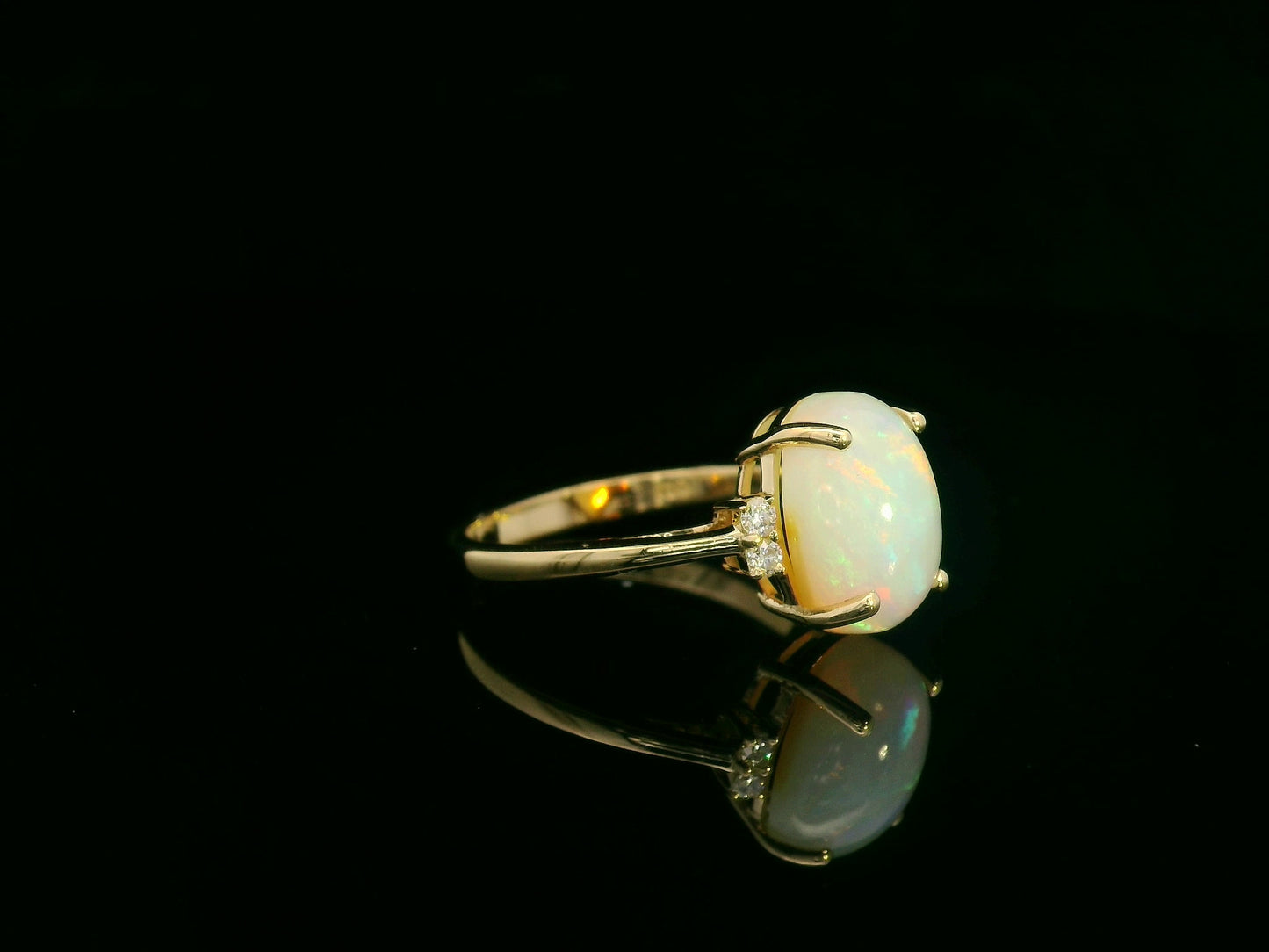 18K yellow gold opal and diamond ring featuring a 2.60 carat oval opal with diamond accents by Emirates Diamonds