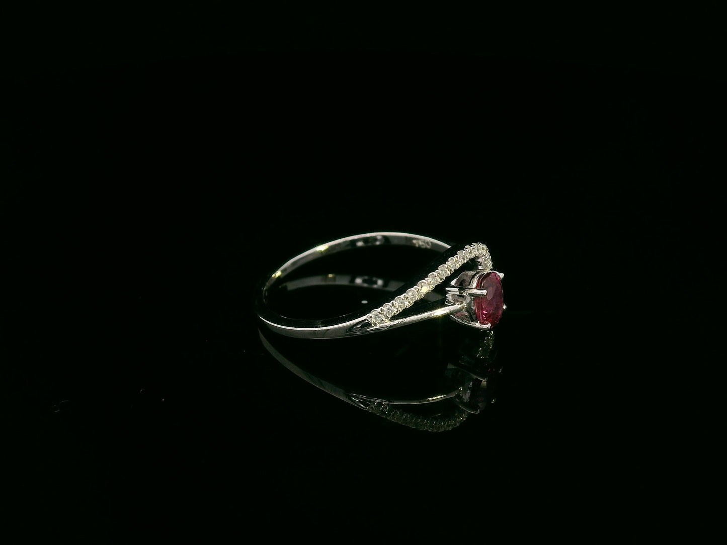 18K white gold ruby and diamond curved ring with oval ruby and flowing diamond-accented band by Emirates Diamonds