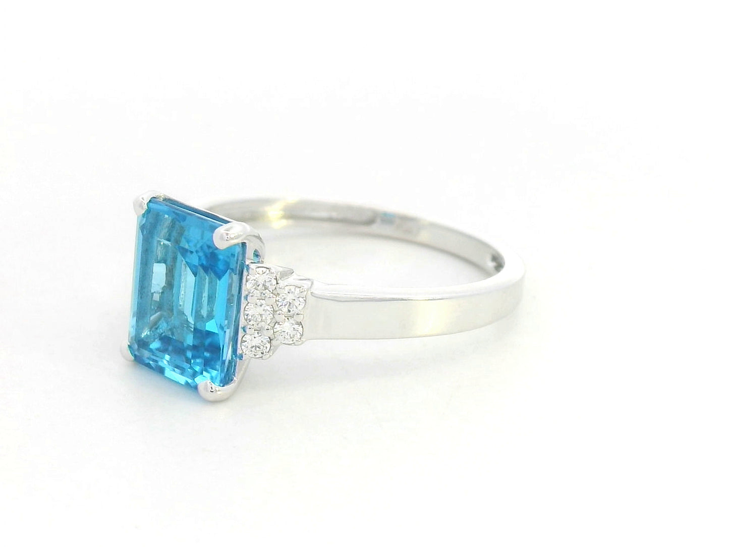 18K white gold emerald-cut Swiss blue topaz ring with diamond side accents by Emirates Diamonds