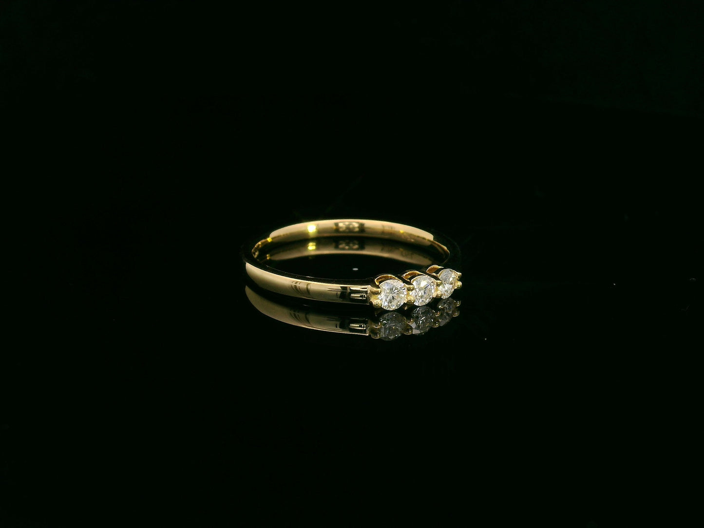 18K yellow gold diamond three-stone ring with round brilliant diamonds, classic trilogy ring design by Emirates Diamonds