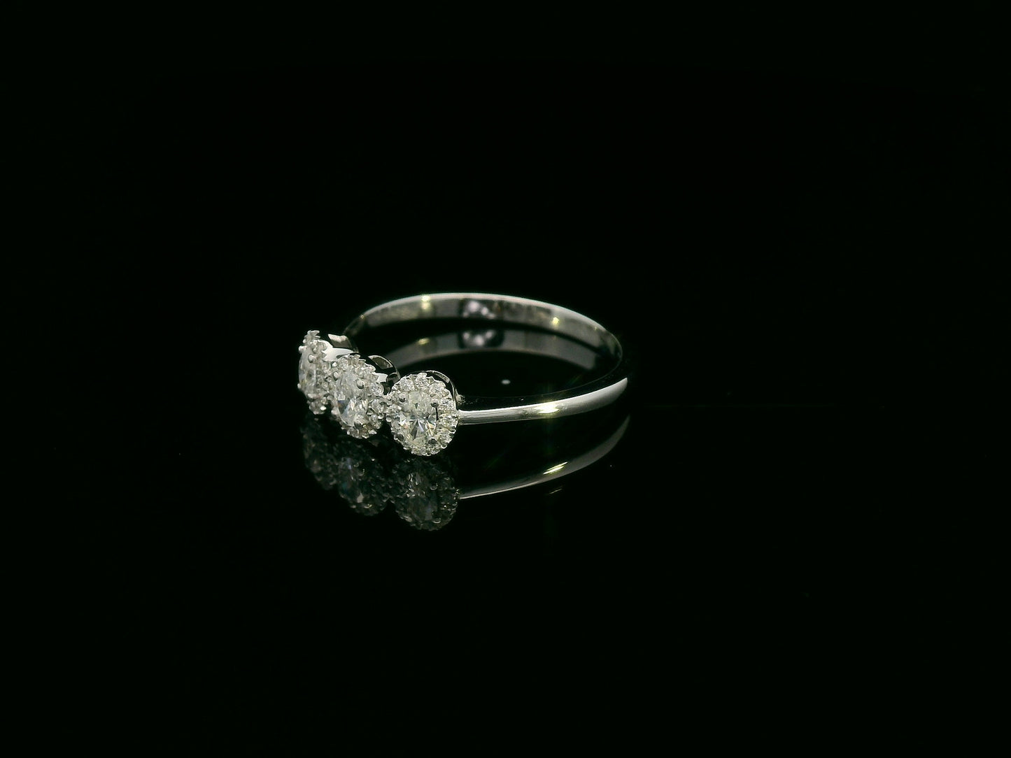 Diamond trilogy halo ring in 18K white gold with three round diamond clusters