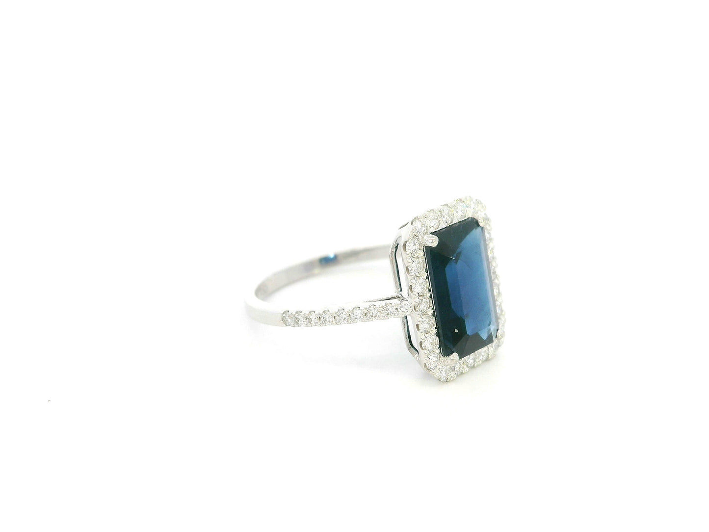 Emerald cut blue sapphire halo ring in 18K white gold with diamond accents Emirates Diamonds