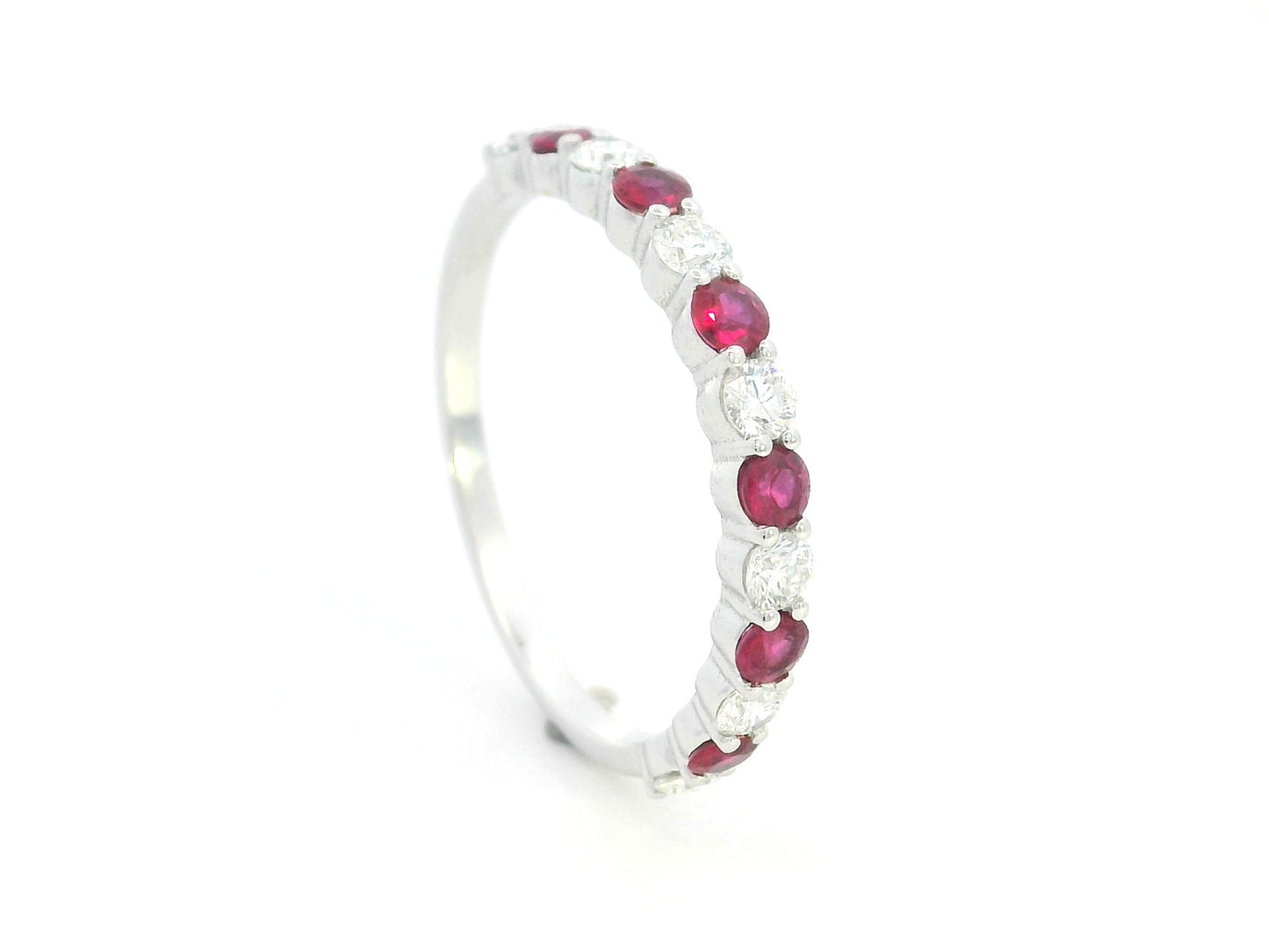 Ruby and diamond half eternity ring in 18K white gold with alternating round rubies and diamonds.
