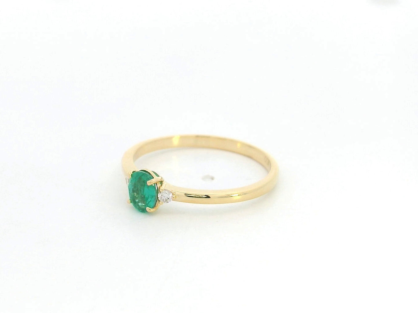Dainty oval emerald and diamond ring in 18K yellow gold by Emirates Diamonds