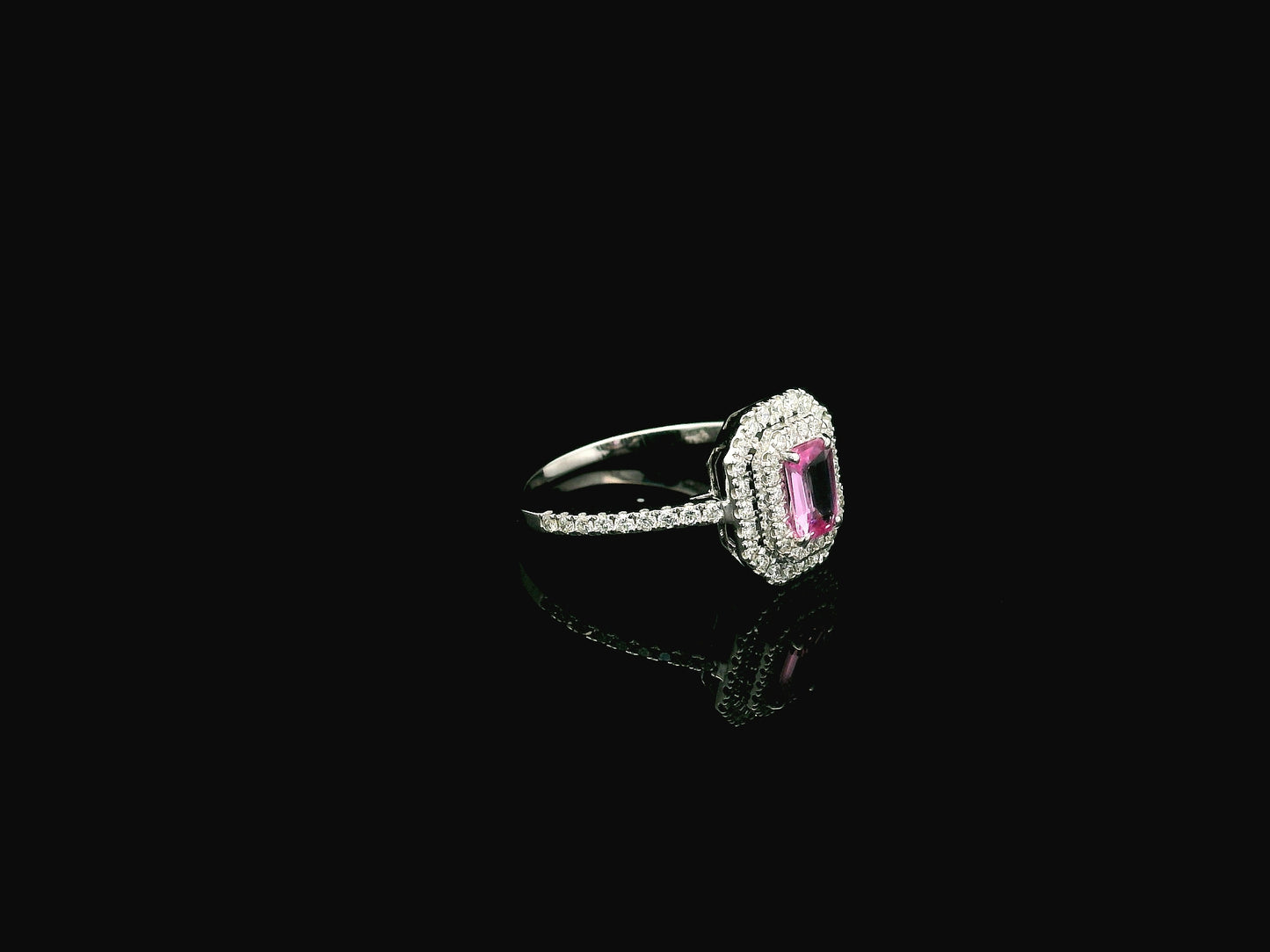 18K white gold pink sapphire halo ring featuring a 0.55 carat emerald-cut pink sapphire surrounded by a double halo of natural diamonds totaling 0.40 carat.