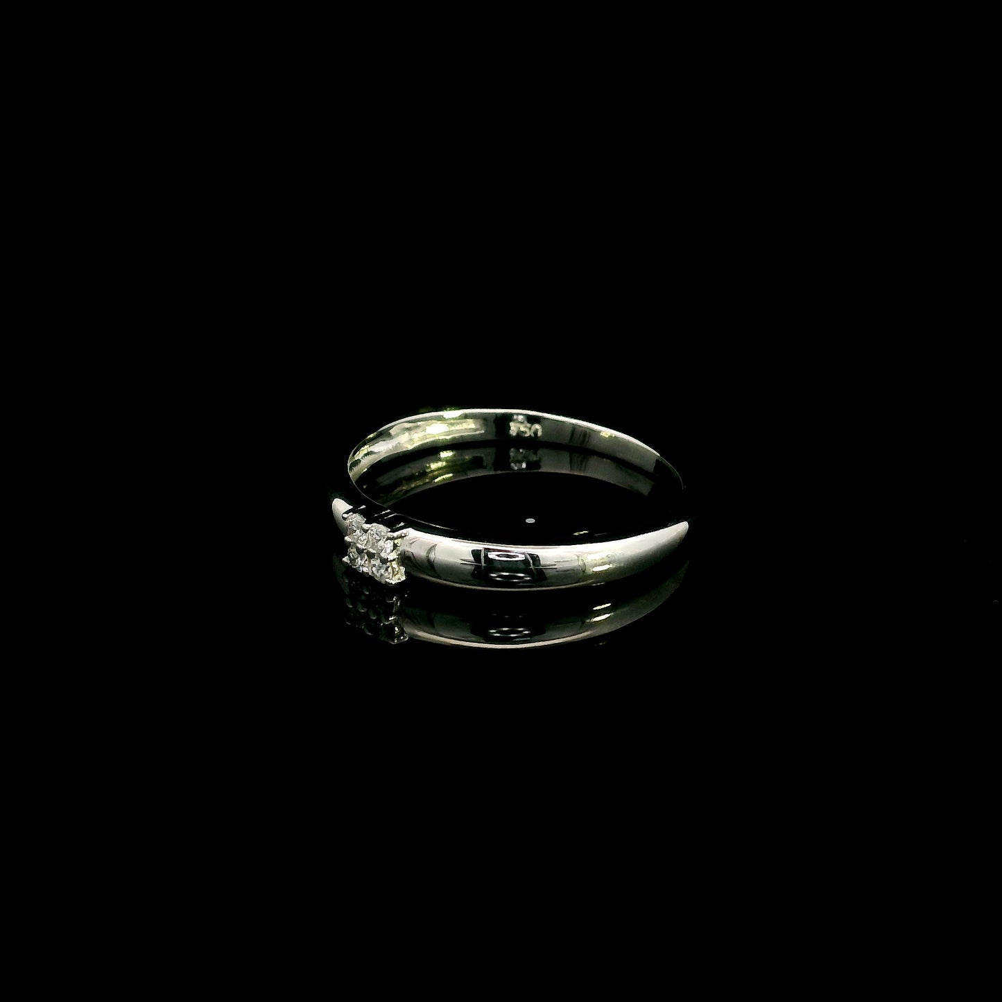 Minimalist natural diamond ring crafted in 18K white gold featuring a polished band with a four-diamond cluster.