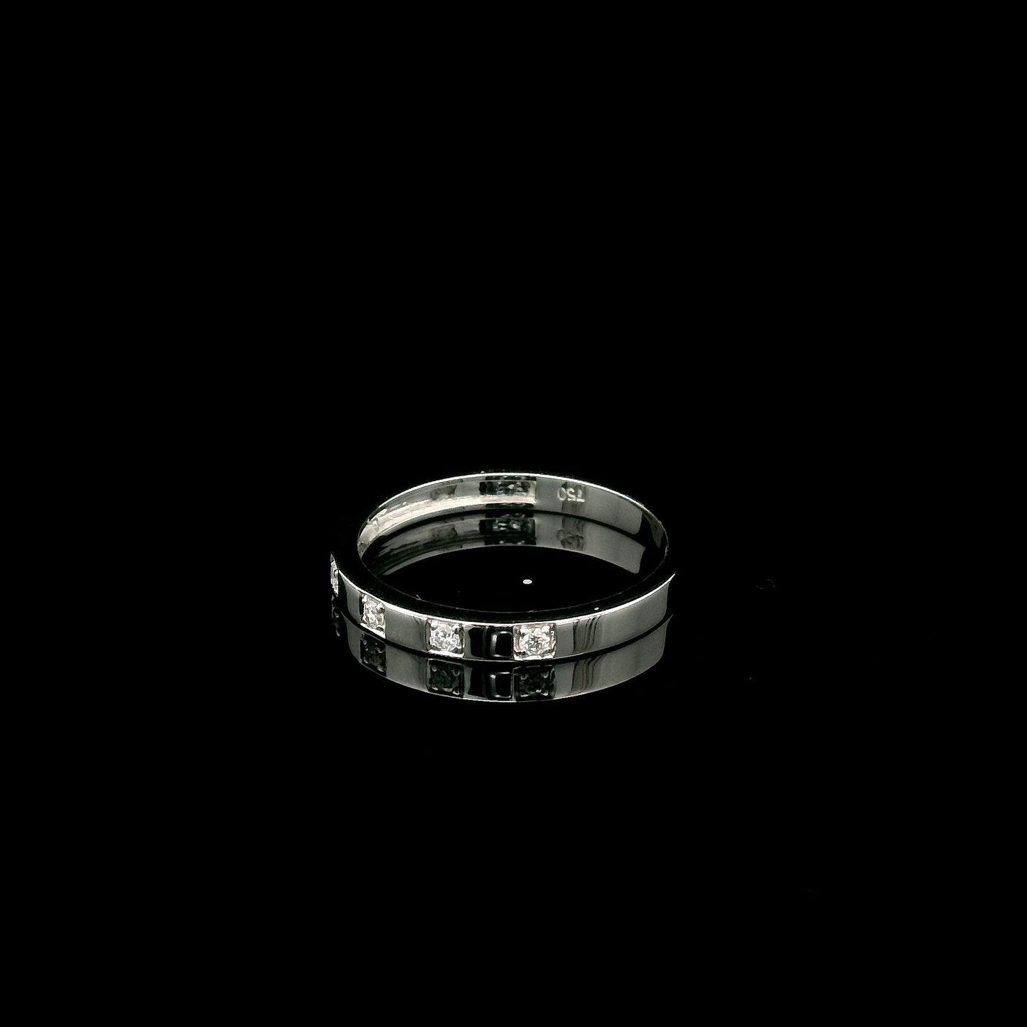 18K white gold diamond wedding band featuring five natural round brilliant diamonds in a modern flush-style polished band.