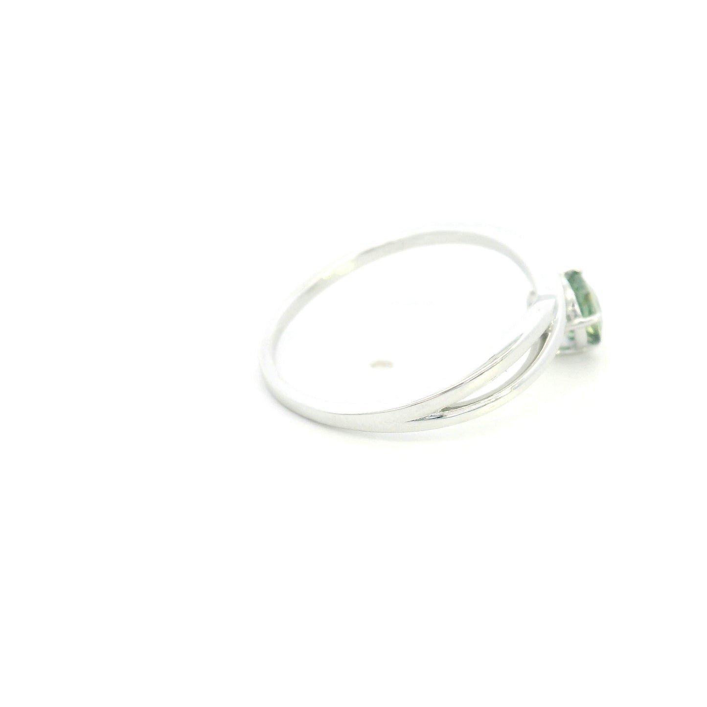 18K white gold crossover ring featuring a natural 0.88 carat round green sapphire in a contemporary solitaire design.