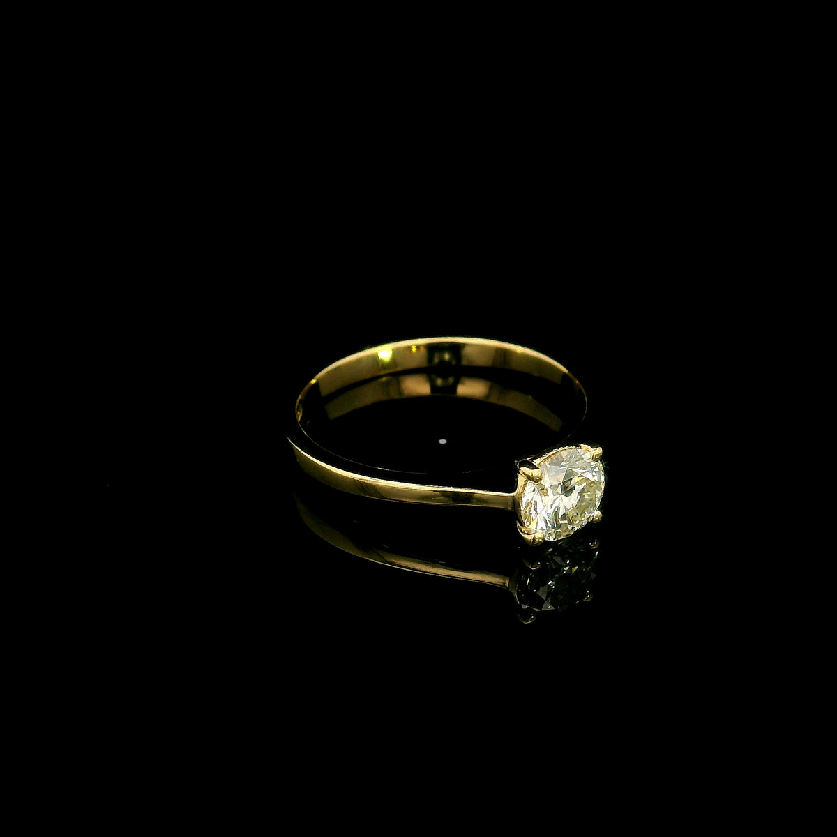 Round diamond solitaire engagement ring in 18K yellow gold with four-prong setting and tapered band