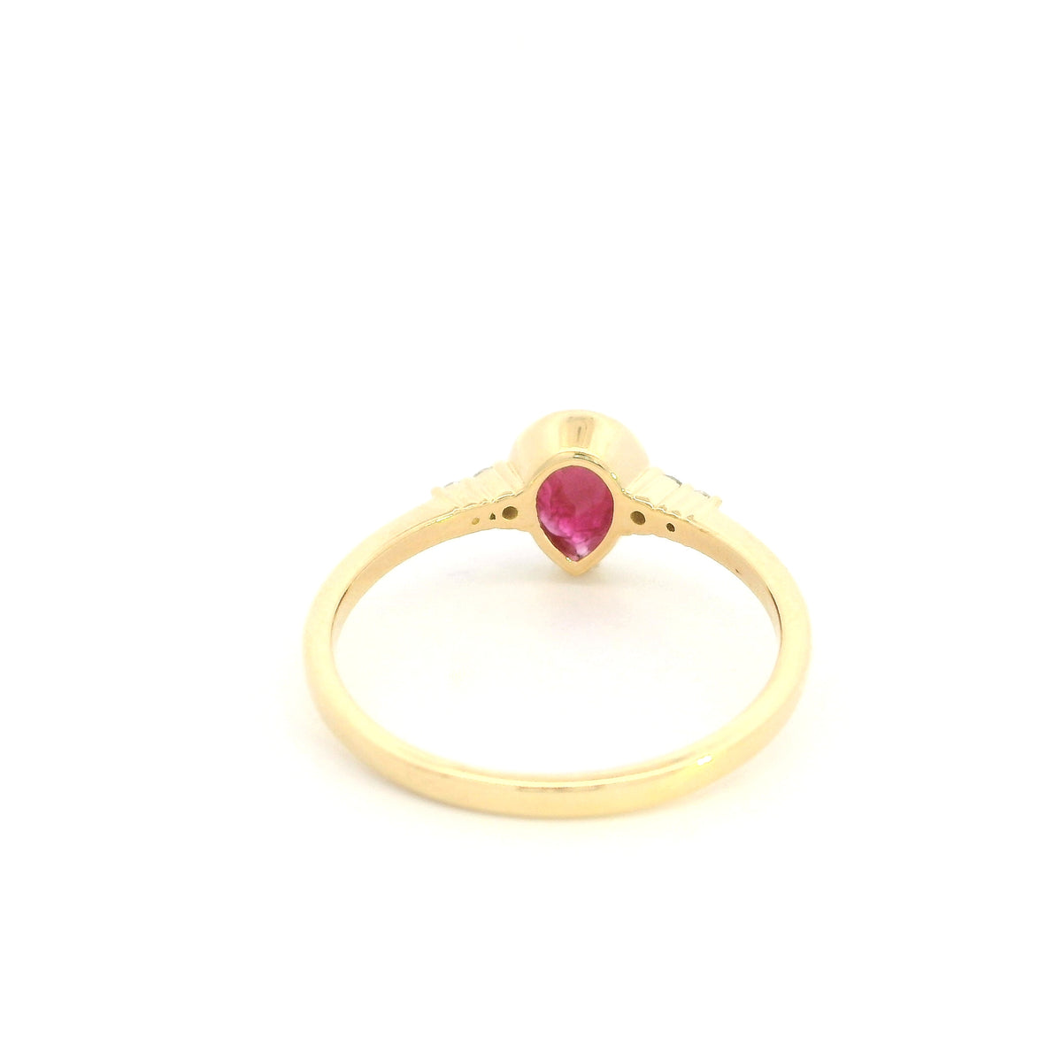 Pear-shaped red ruby ring in 18K yellow gold with a smooth bezel setting and small round diamonds along both shoulders.