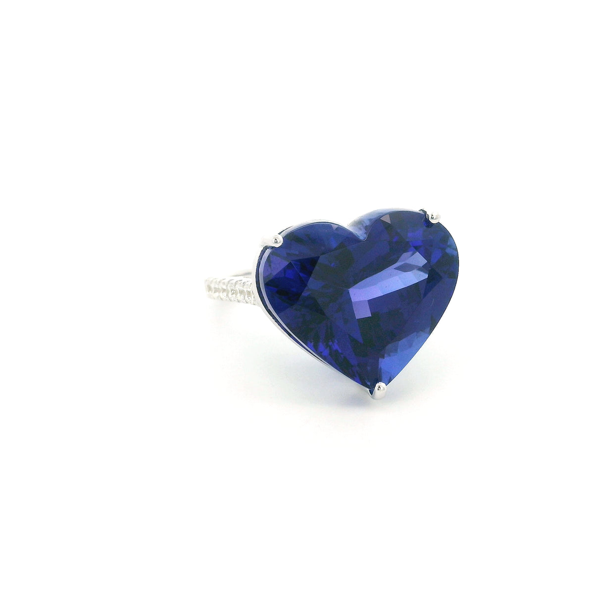 Heart shaped tanzanite ring in 18K white gold featuring a 25.18 carat blue-violet gemstone and diamond-set shoulders.