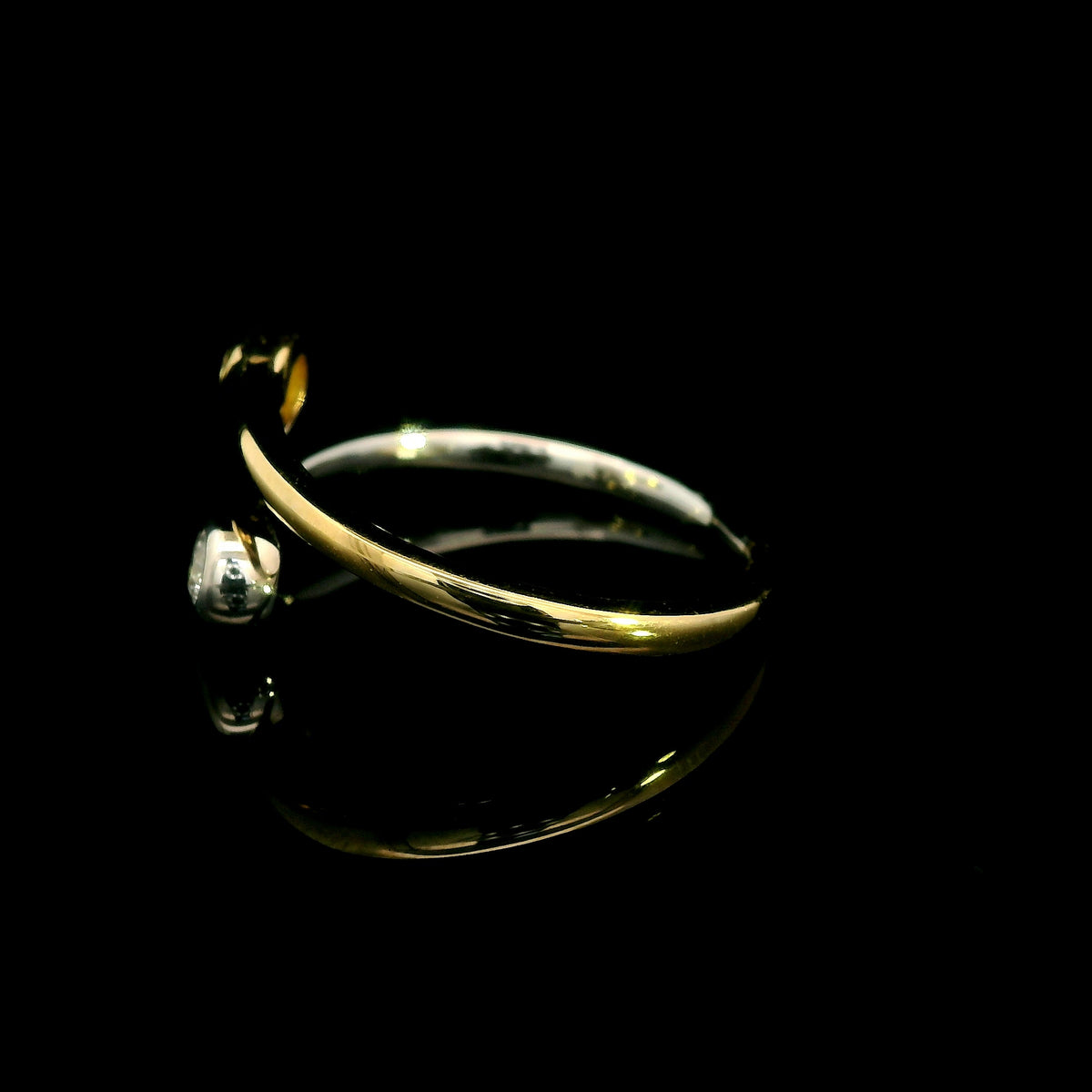 18K white and yellow gold bypass ring with two round diamonds in bezel settings at the ends of curved, overlapping bands.