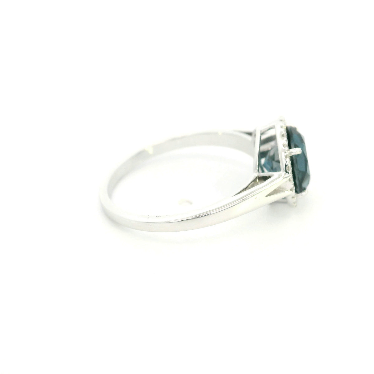 18K white gold ring with a deep blue London blue topaz surrounded by round diamonds and a split-shoulder band.