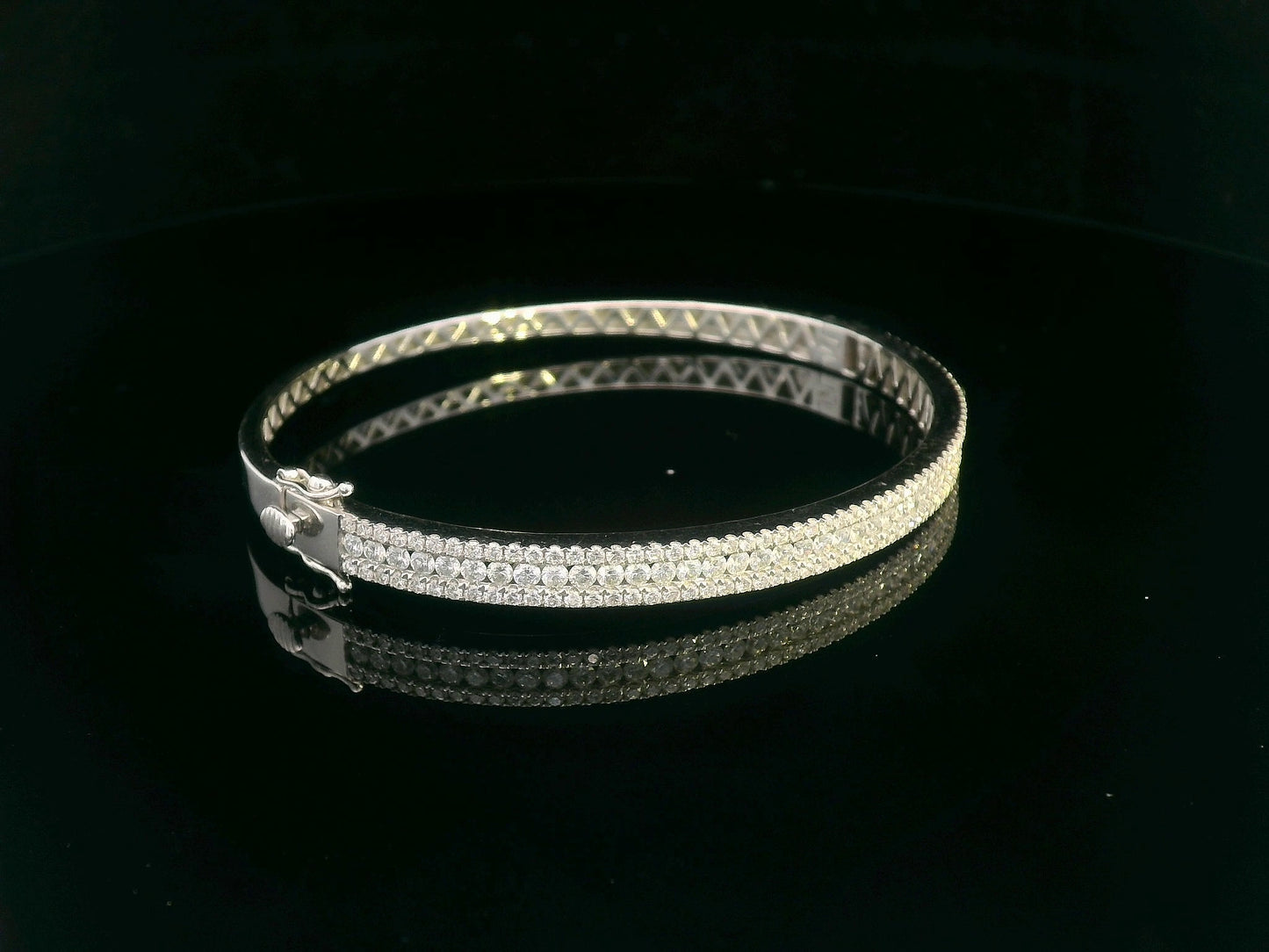18K white gold bangle with triple row diamond setting featuring 2.36 carats of round diamonds and a secure clasp