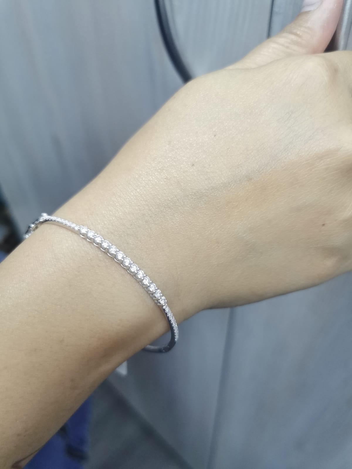 Minimalist 18K gold bangle with 1.03 carat dual-size round-cut diamonds, polished finish