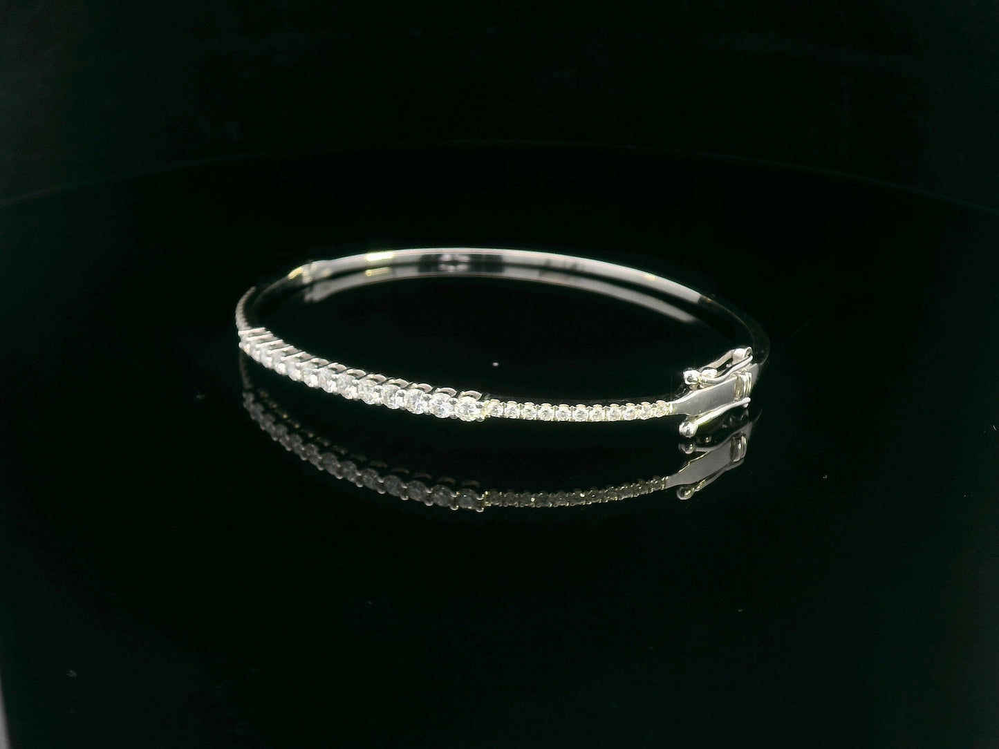Minimalist 18K gold bangle with 1.03 carat dual-size round-cut diamonds, polished finish