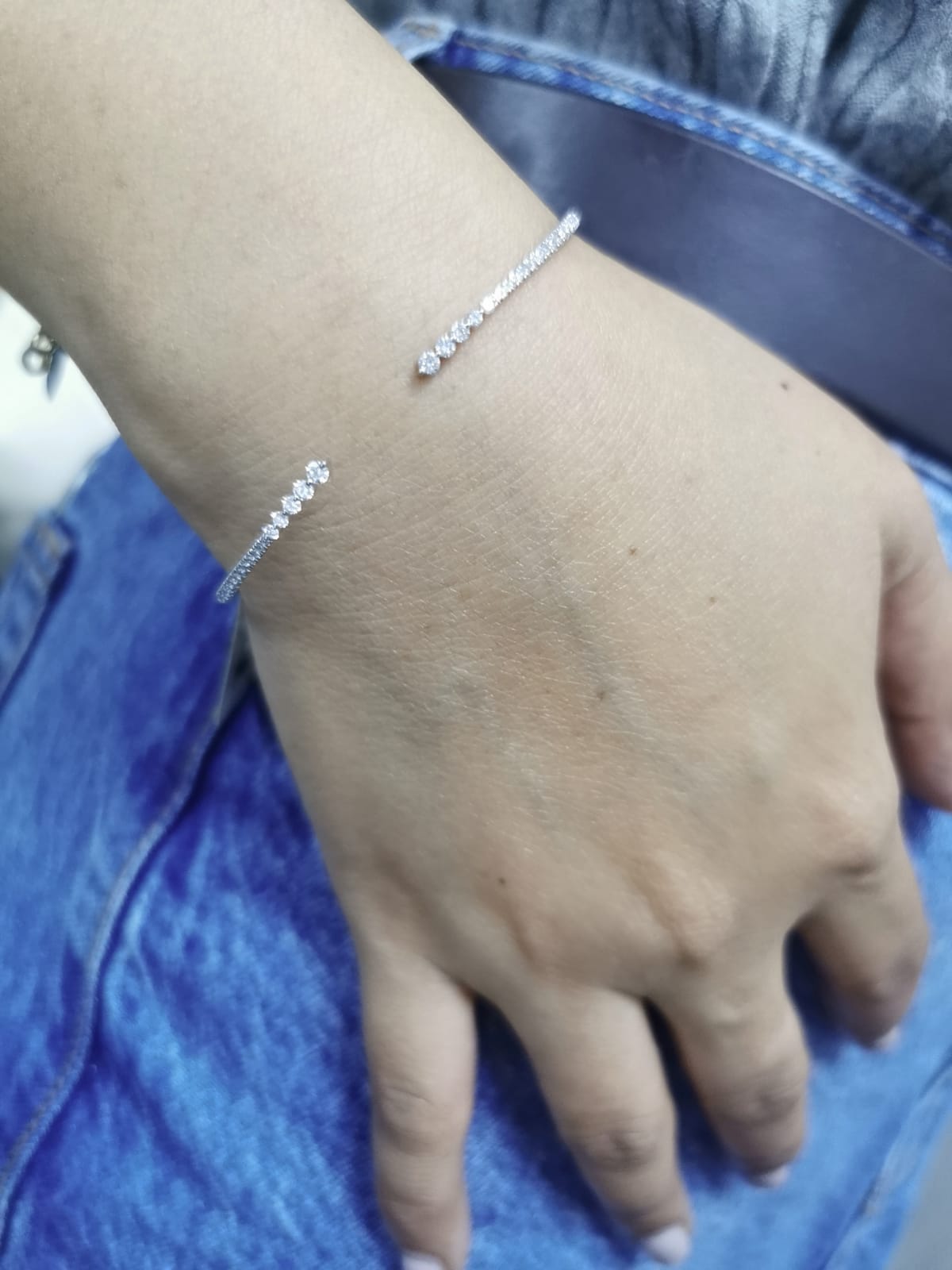 18K gold open diamond bangle bracelet with graduated diamonds, featuring a sleek and modern minimalist design.