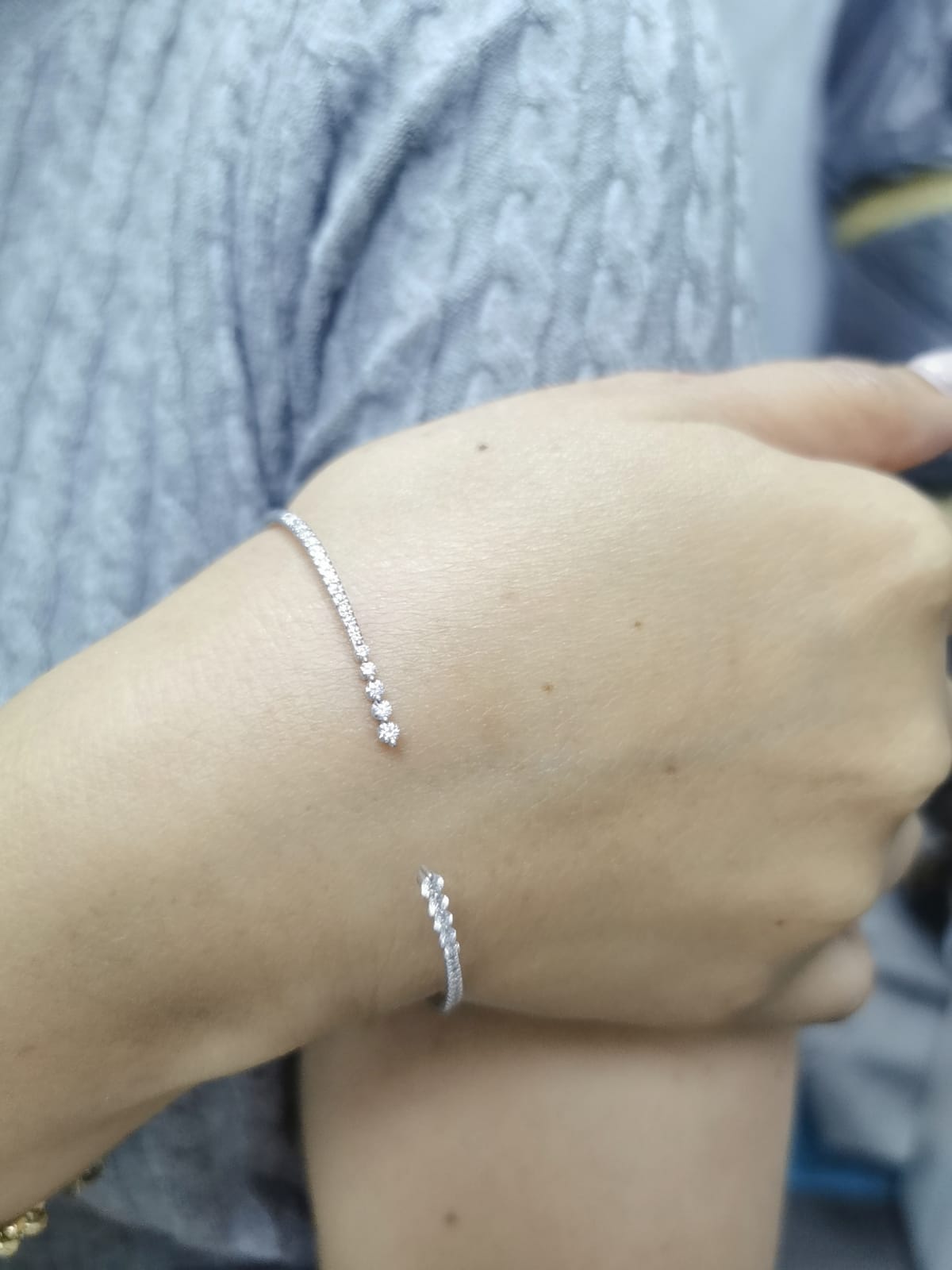 18K gold open diamond bangle bracelet with graduated diamonds, featuring a sleek and modern minimalist design.
