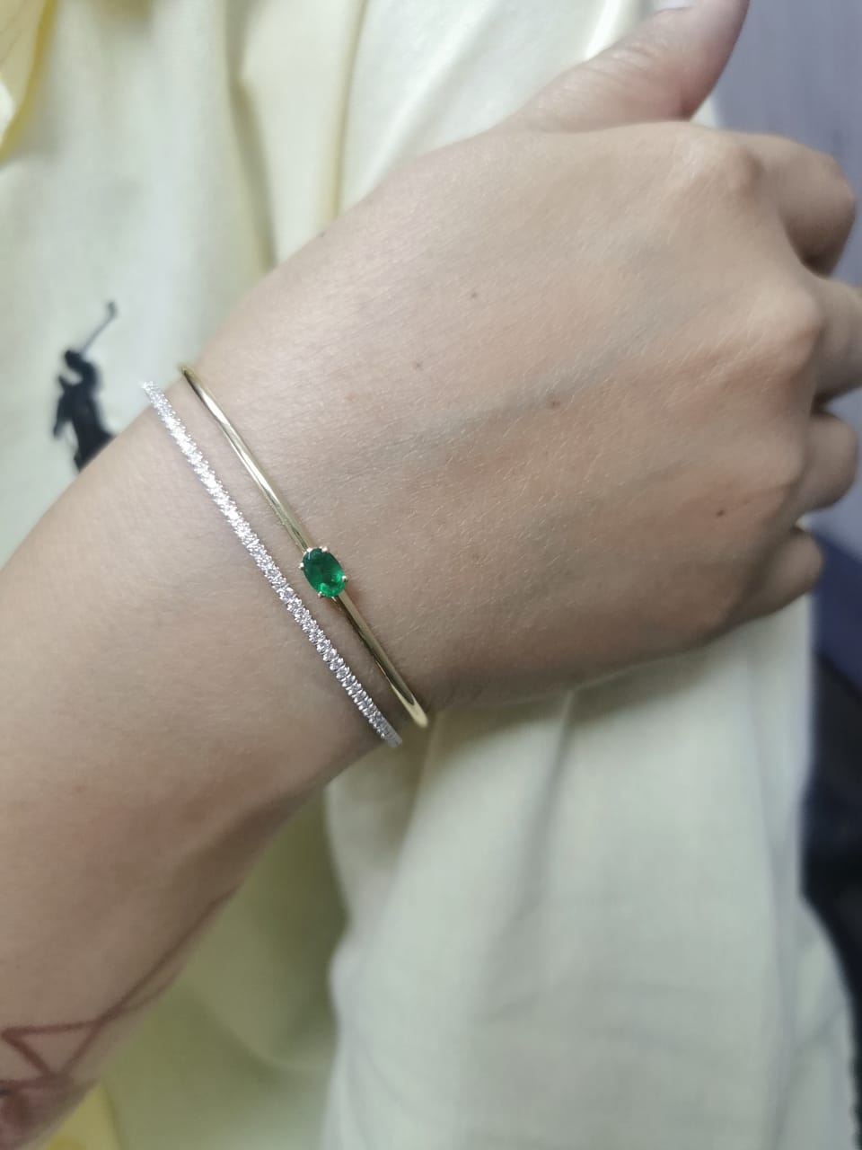 18K yellow gold open bangle with oval emerald and diamond band – 0.48ct emerald and 0.59ct diamond