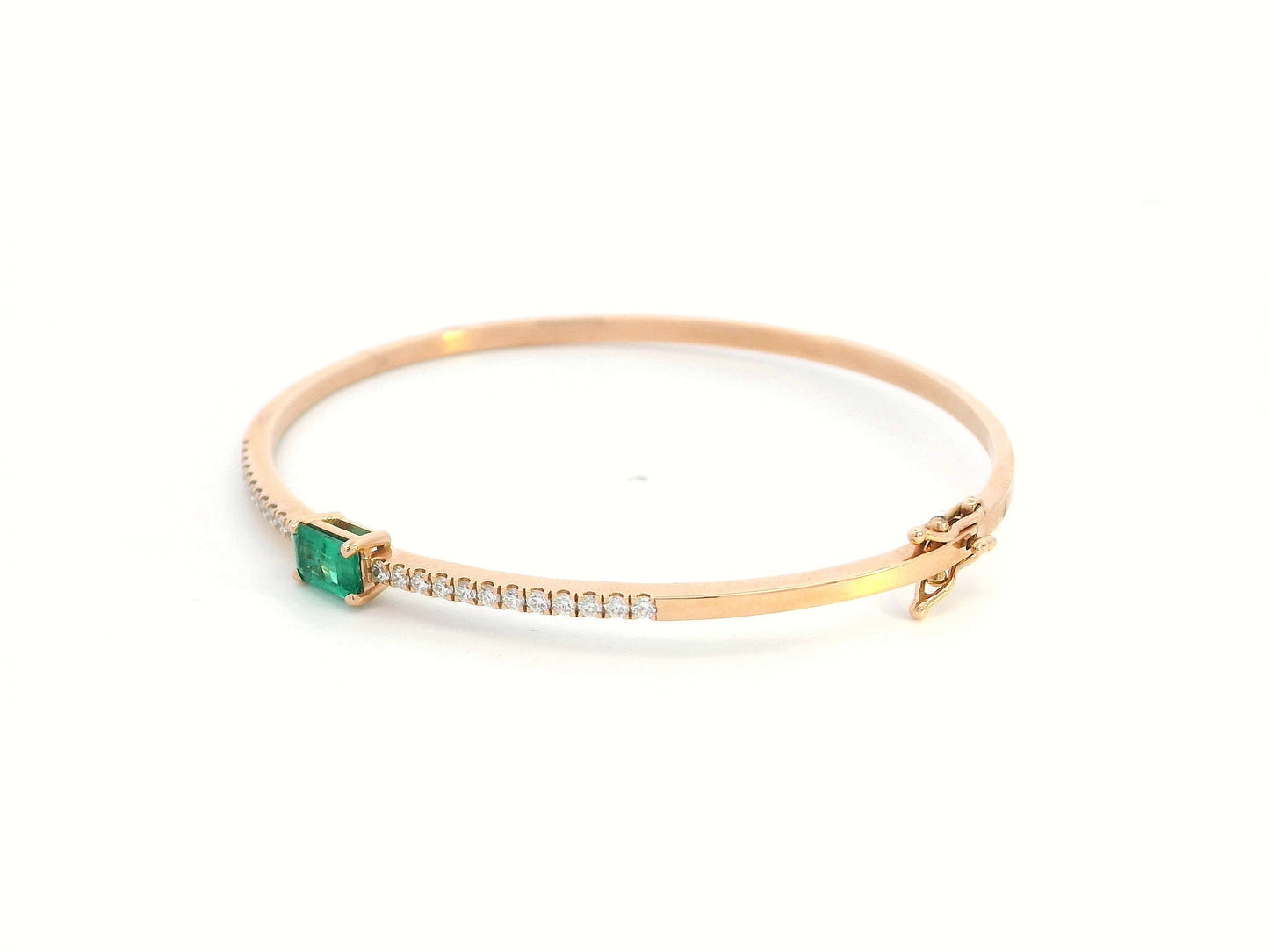 18K gold bangle with emerald-cut 0.50 carat green emerald and 0.34 carat round diamonds in a hinged bracelet design.