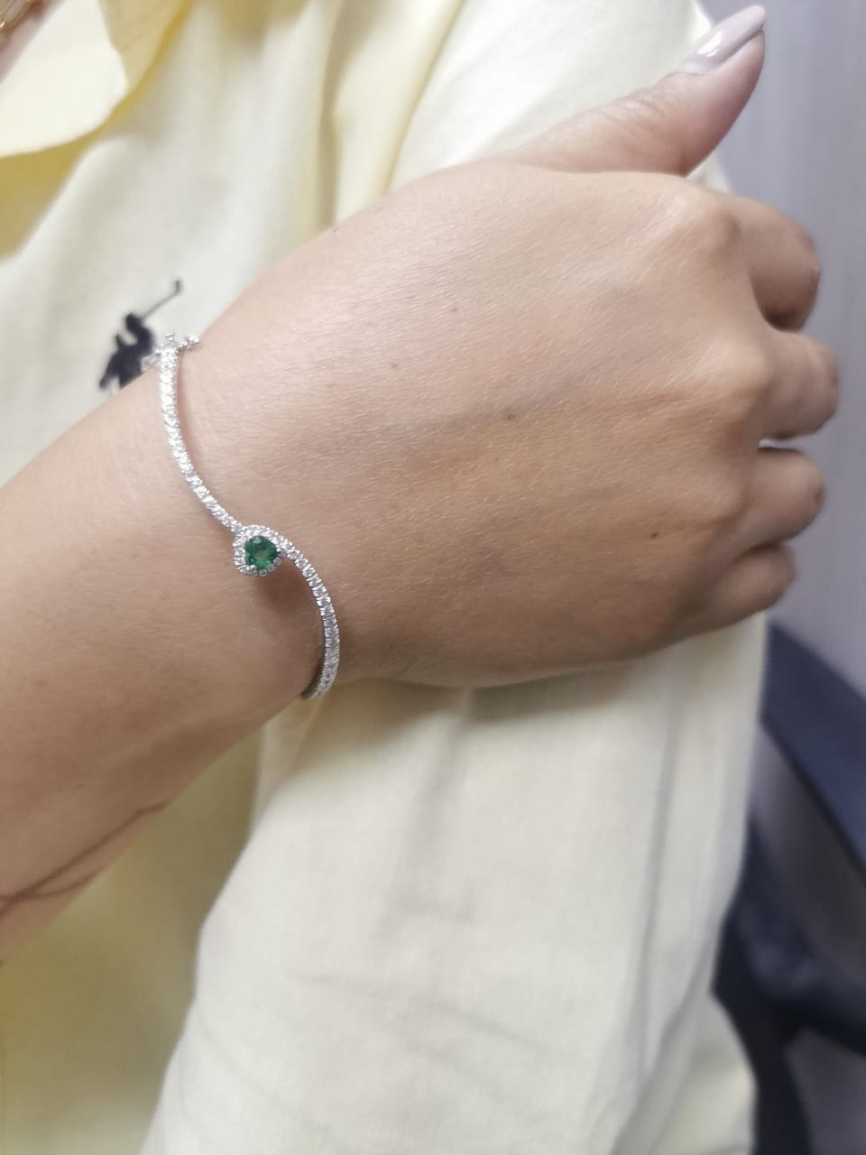 18K white gold bangle with heart-shaped emerald and pavé diamonds, elegant curved design