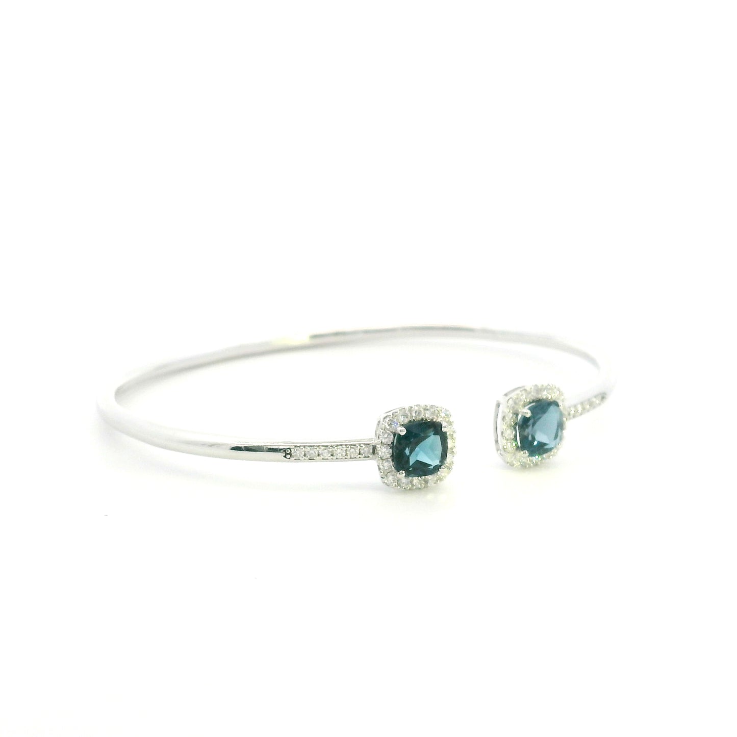 London Blue Topaz and diamond open bangle in 18K white gold with two cushion-cut blue topaz gemstones and diamond surrounds
