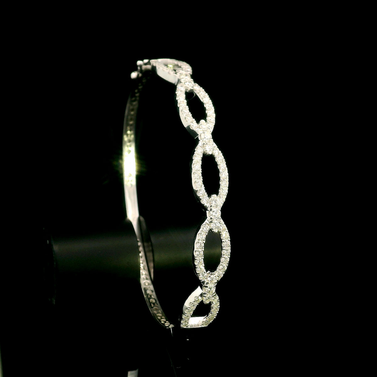 Diamond loop bangle in 18K white gold with repeating diamond-set open loops across the front.