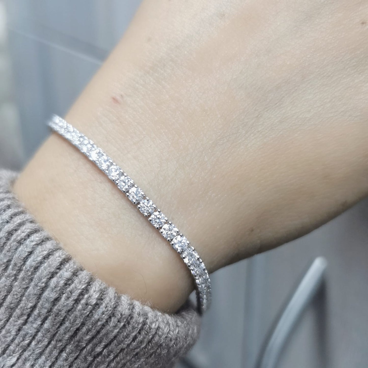 18K white gold tennis bracelet featuring 5.58 carats of round brilliant diamonds