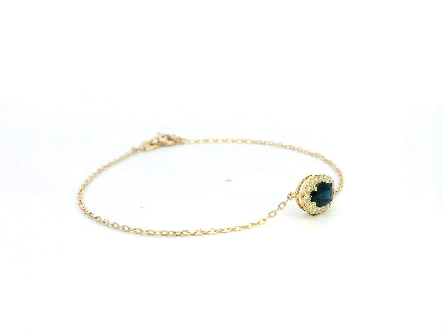 18K yellow gold bracelet with oval blue sapphire and round diamond halo on fine gold chain.