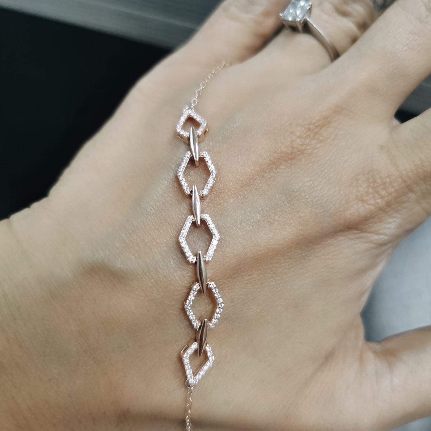 18K gold bracelet with five diamond-encrusted hexagon links and chain-link design