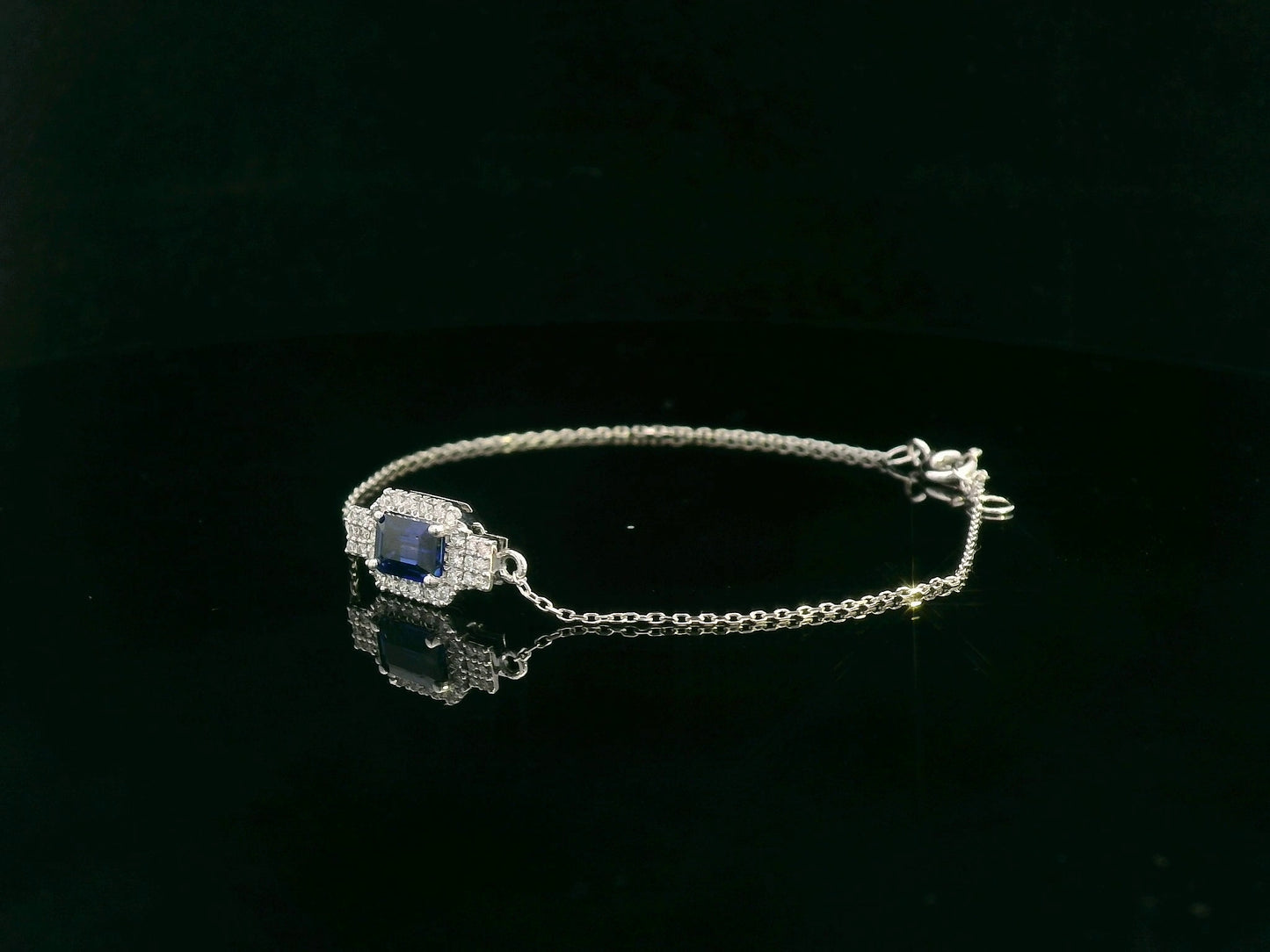 18K white gold sapphire halo bracelet with emerald-cut 0.80ct blue sapphire and diamond accents – Emirates Diamonds.