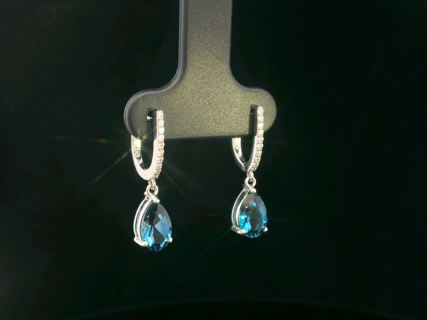 18K gold drop earrings featuring pear-cut London Blue Topaz (1.94 carats) with round-cut diamonds (0.08 carats), set in elegant diamond-studded huggie hoops.