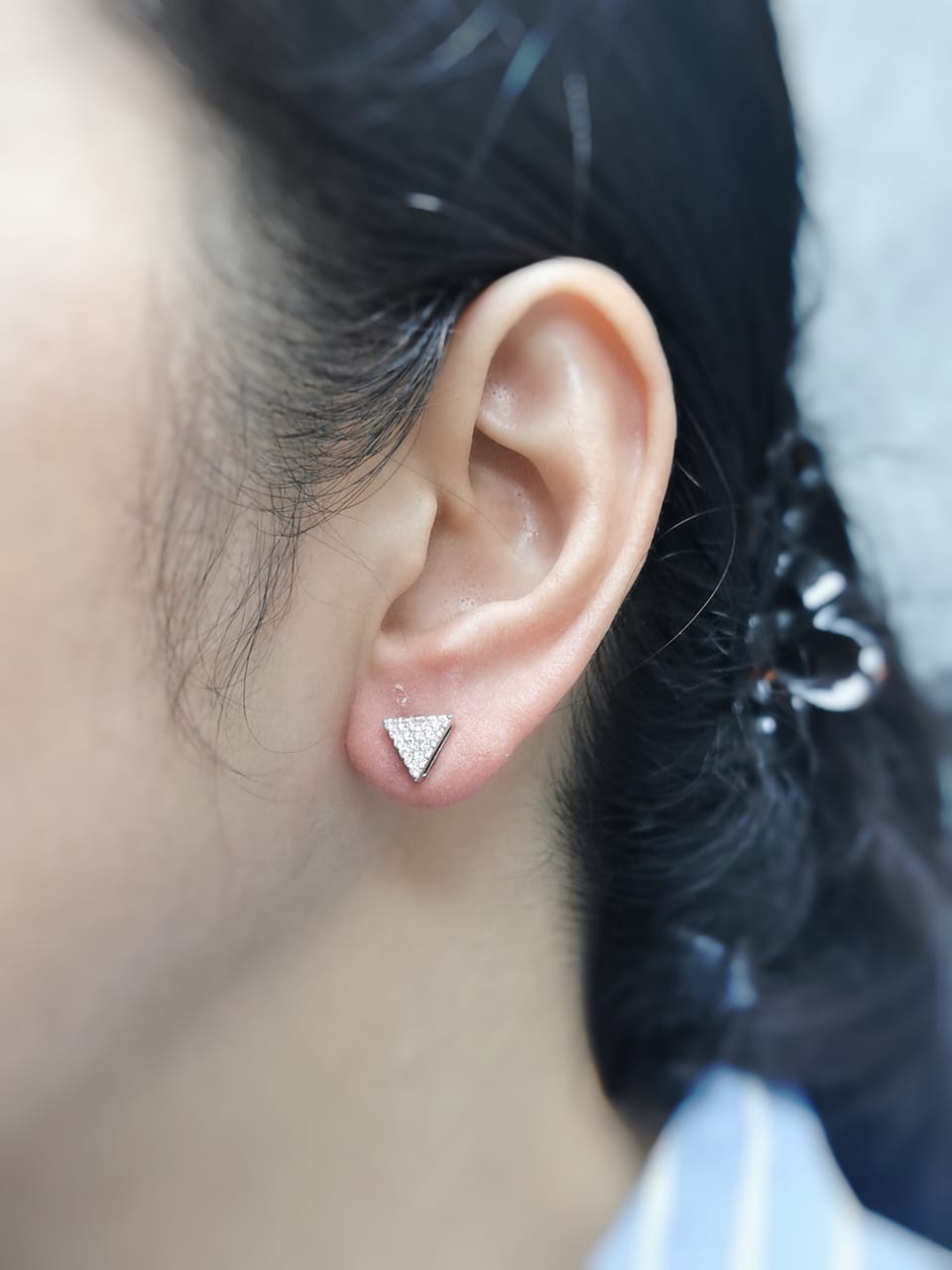 A pair of minimalist 18K white gold triangle diamond earrings featuring a geometric triangular design with 0.30 carats of round-cut diamonds and push-back closures.