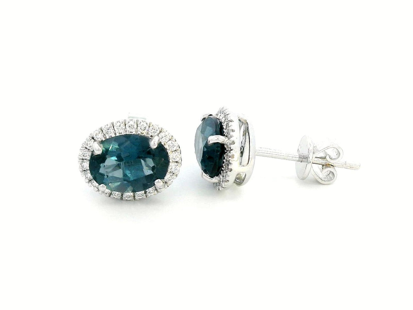 18K gold stud earrings featuring 2.90 carats of oval London Blue Topaz, encircled by a 0.25-carat diamond halo. Classic elegance with secure push-back closure.