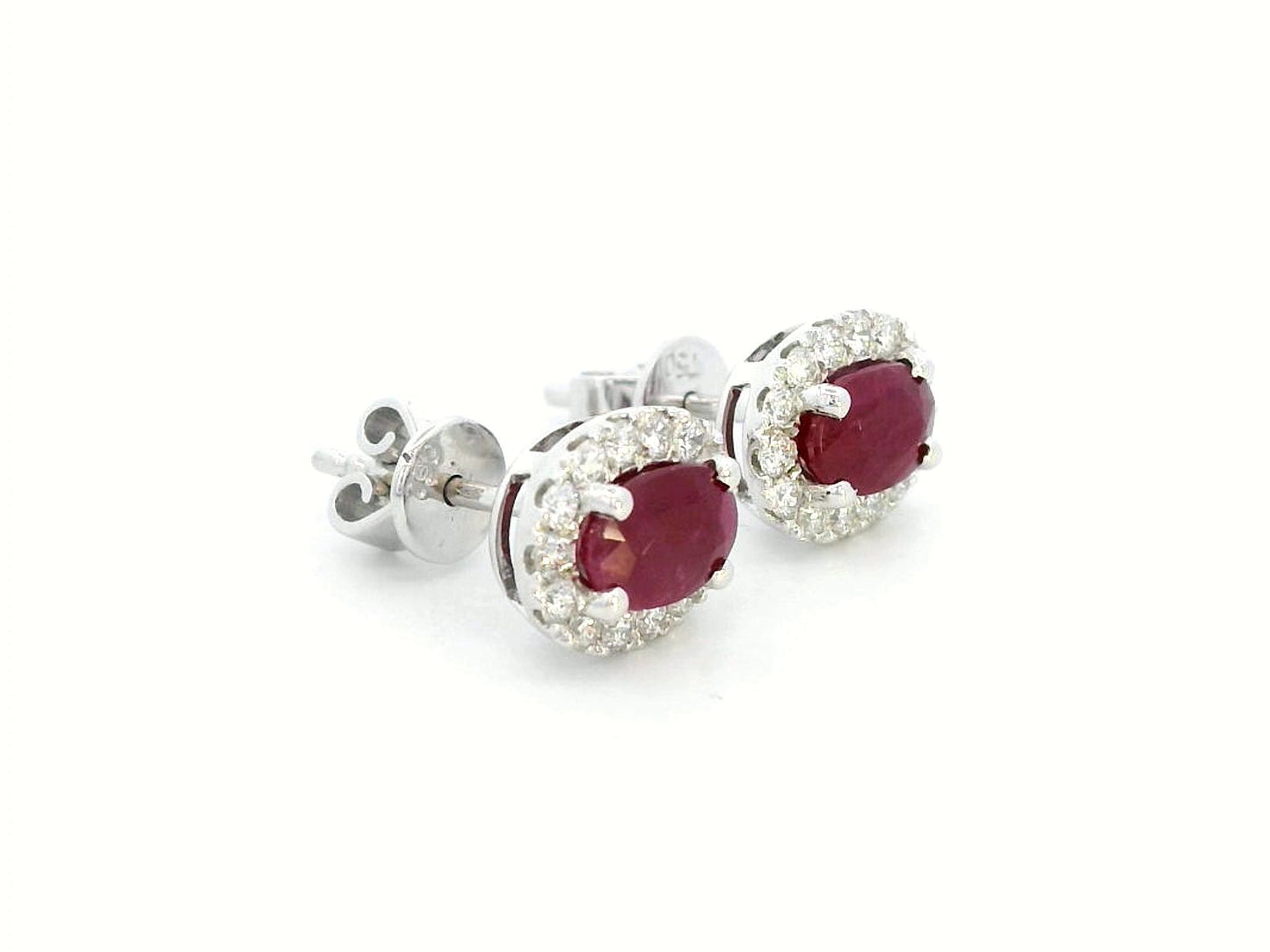 White gold earrings with oval rubies (1.52 CT) and a halo of sparkling diamonds (0.33 CT). Classic and elegant fine jewelry.