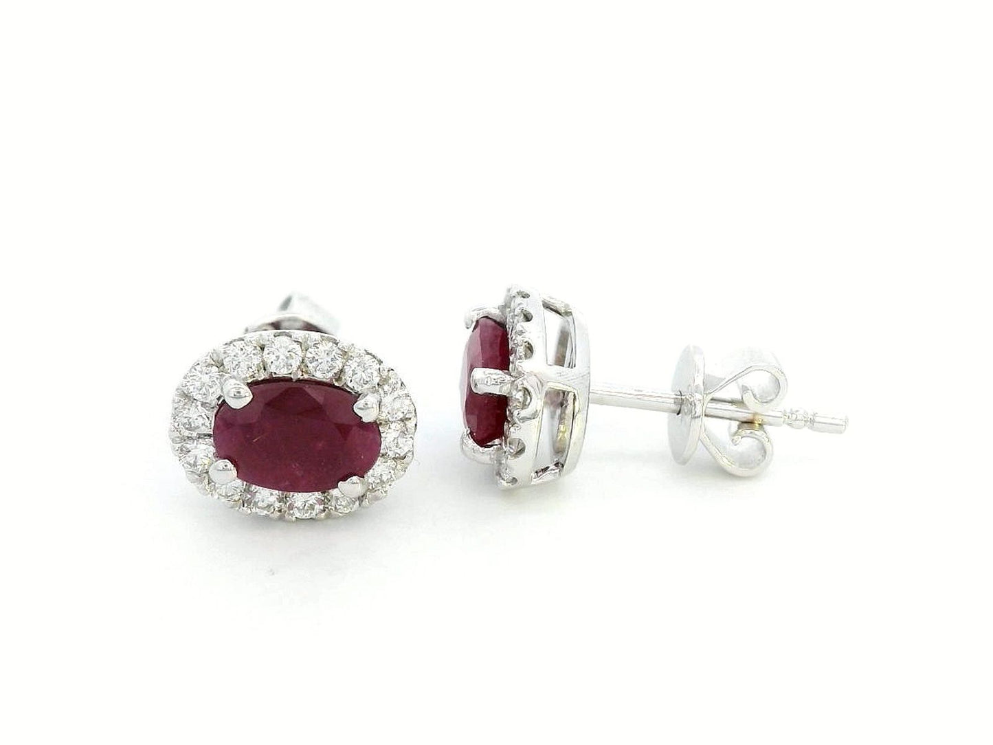 White gold earrings with oval rubies (1.52 CT) and a halo of sparkling diamonds (0.33 CT). Classic and elegant fine jewelry.