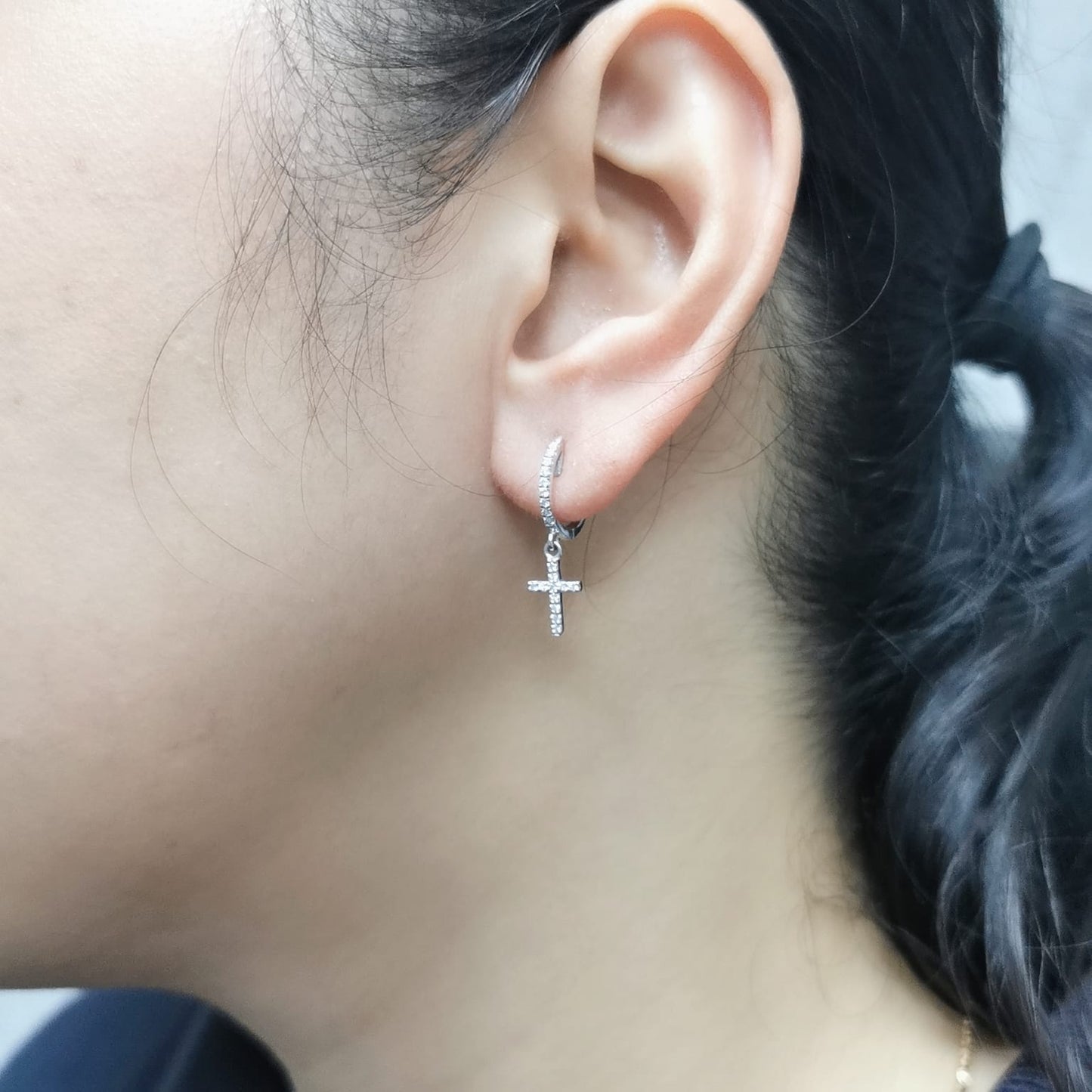18K gold huggie hoop earrings with a 0.22-carat diamond cross charm, featuring pavé-set diamonds and a secure hinged snap closure. Elegant and meaningful.