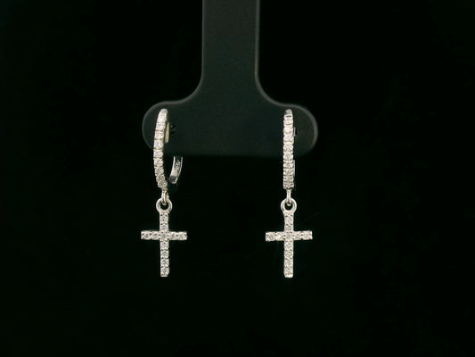 18K gold huggie hoop earrings with a 0.22-carat diamond cross charm, featuring pavé-set diamonds and a secure hinged snap closure. Elegant and meaningful.