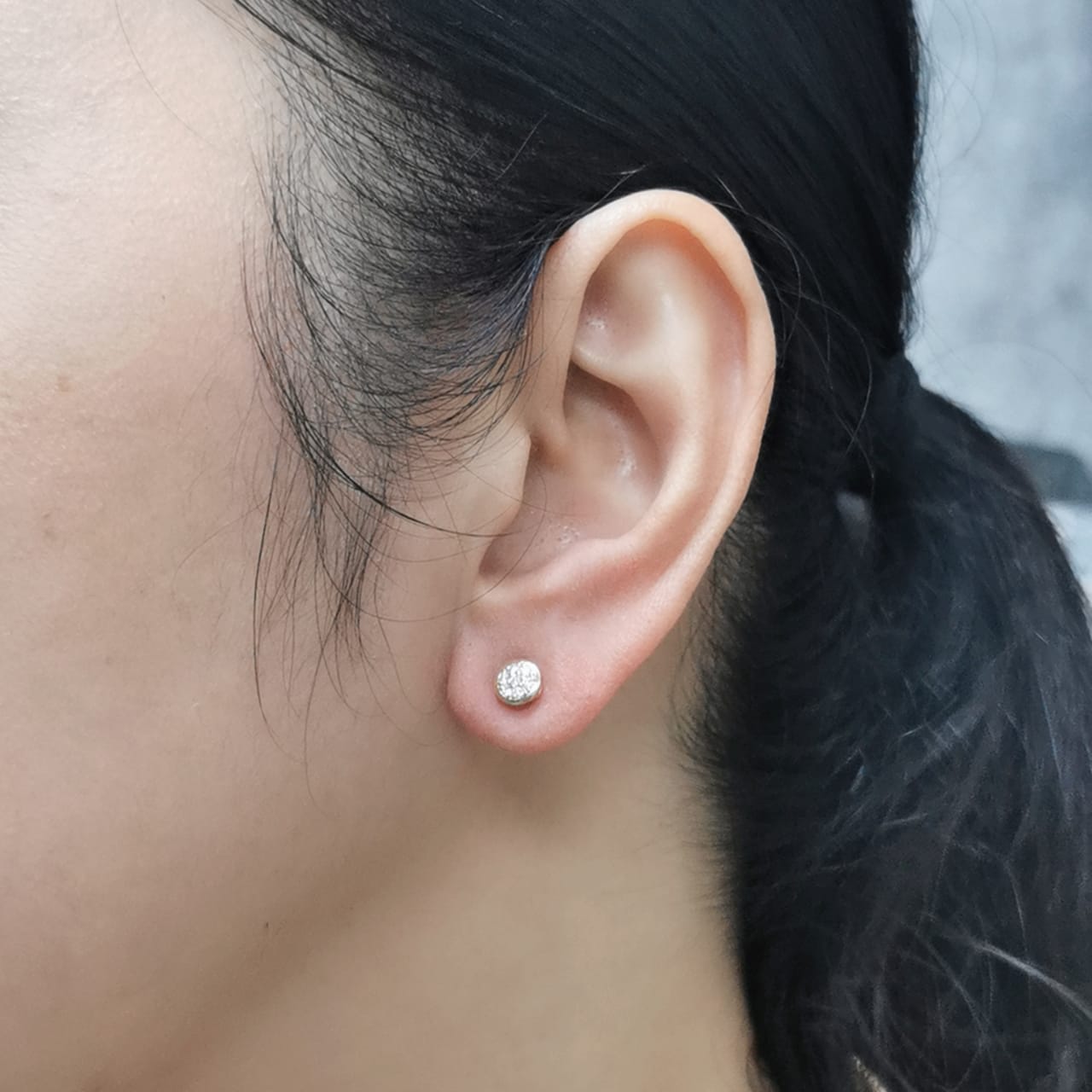 18K gold diamond cluster stud earrings featuring 0.14 carats of round diamonds in a bezel setting, secured with butterfly push-backs.